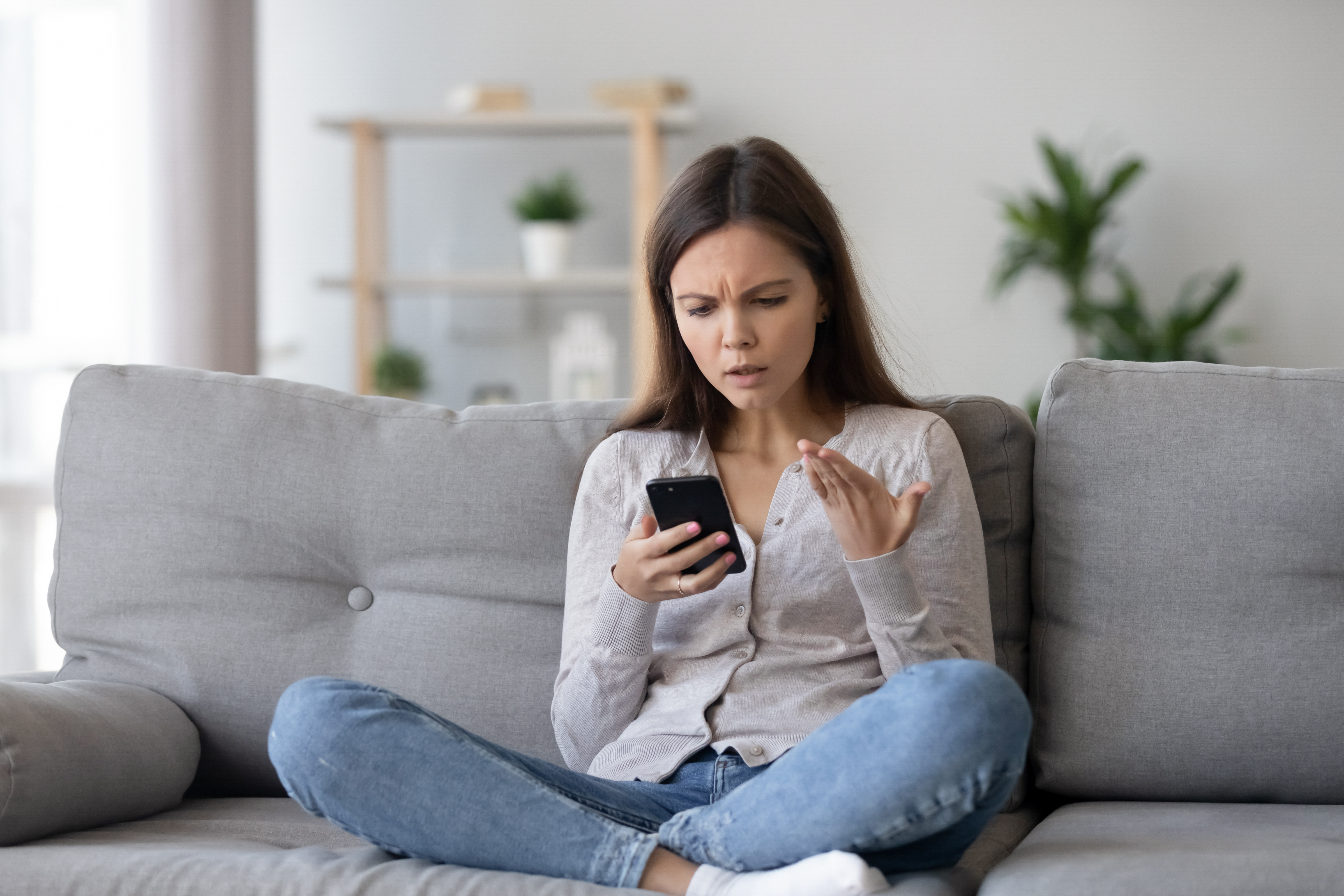 Une femme préoccupée par ce qu'il y a dans son téléphone. | Source : Shutterstock/fizkes