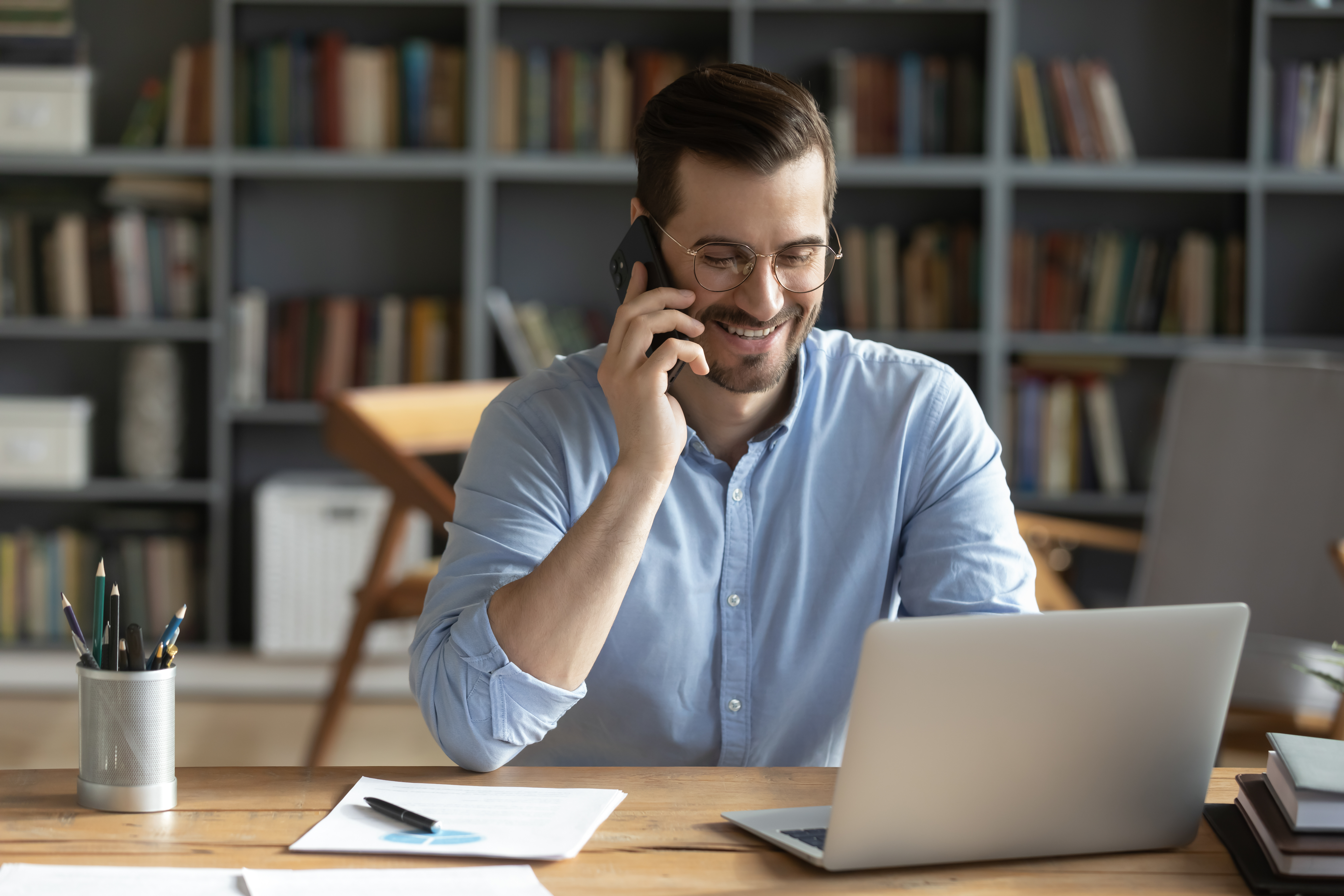 Un homme souriant pendant un appel téléphonique | Source : Shutterstock