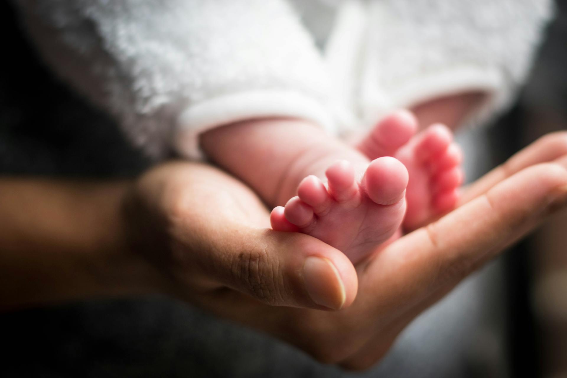 Une personne tenant les pieds d'un bébé | Source : Pexels