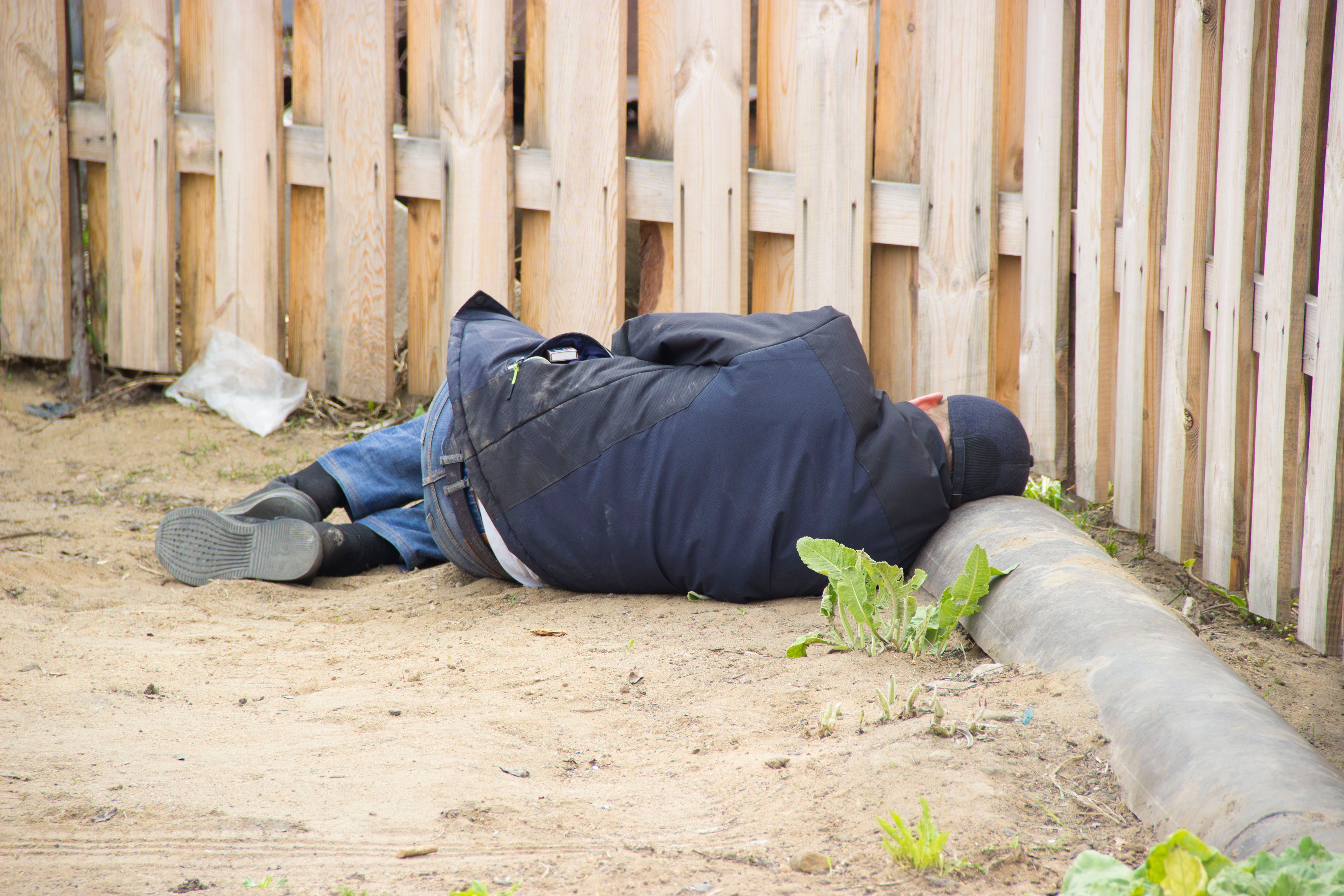 Homme allongé près de la clôture | Source : Shutterstock