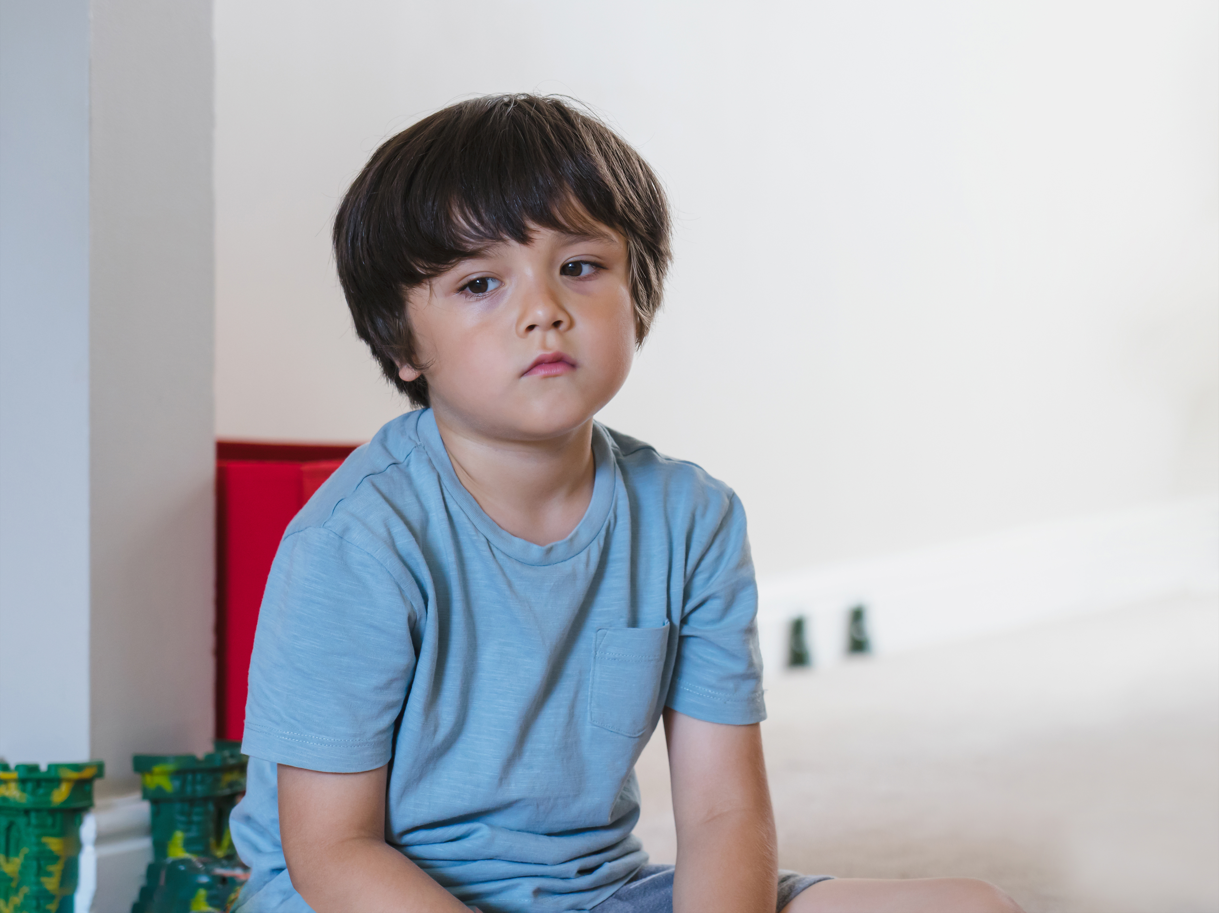 Niño triste sentado en una silla | Fuente: Shutterstock.com