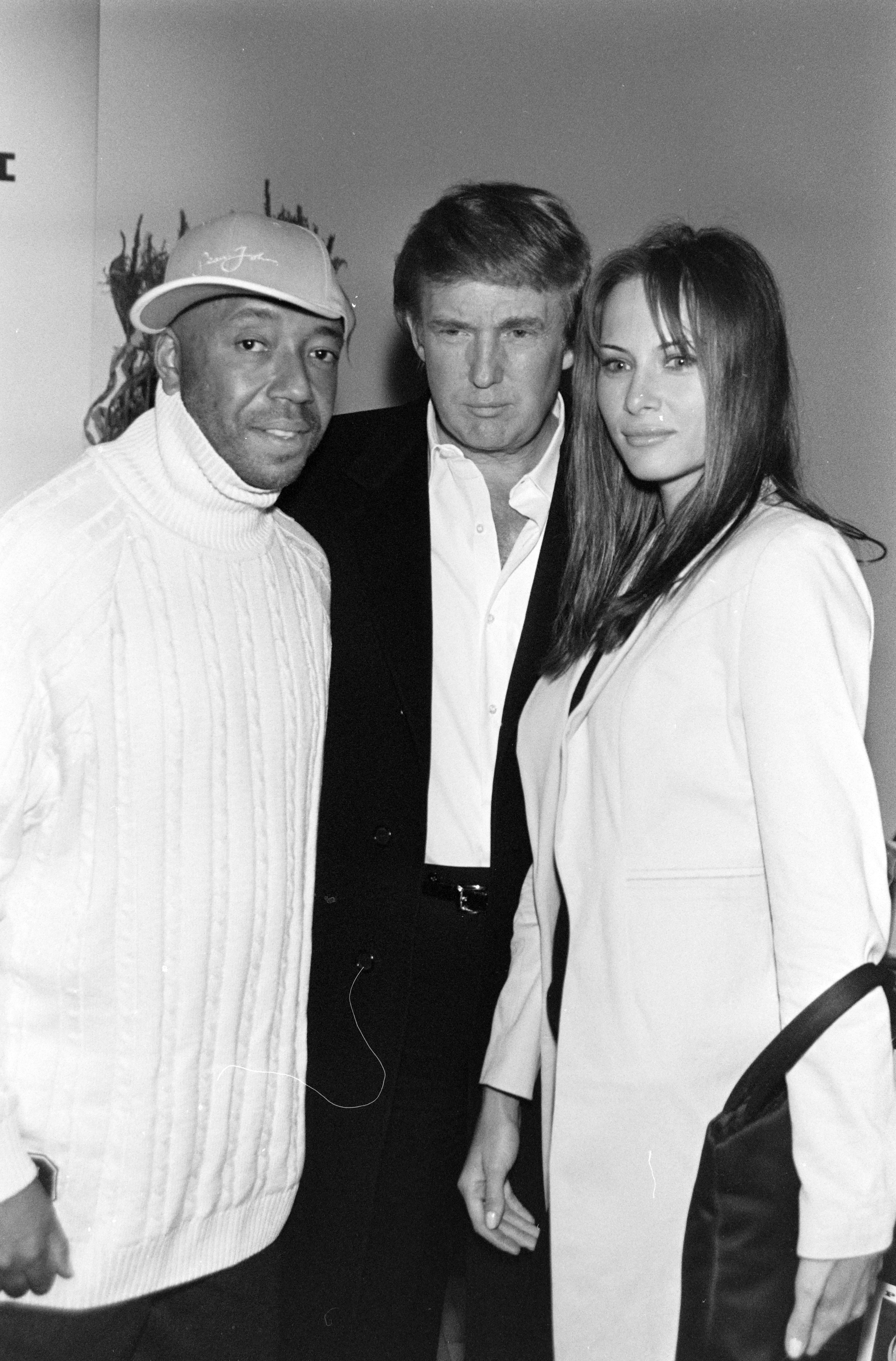 Russell Simmons avec Donald et Melania Trump au défilé de mode prêt-à-porter printemps 1998 de Phat Farm. | Source : Getty Images