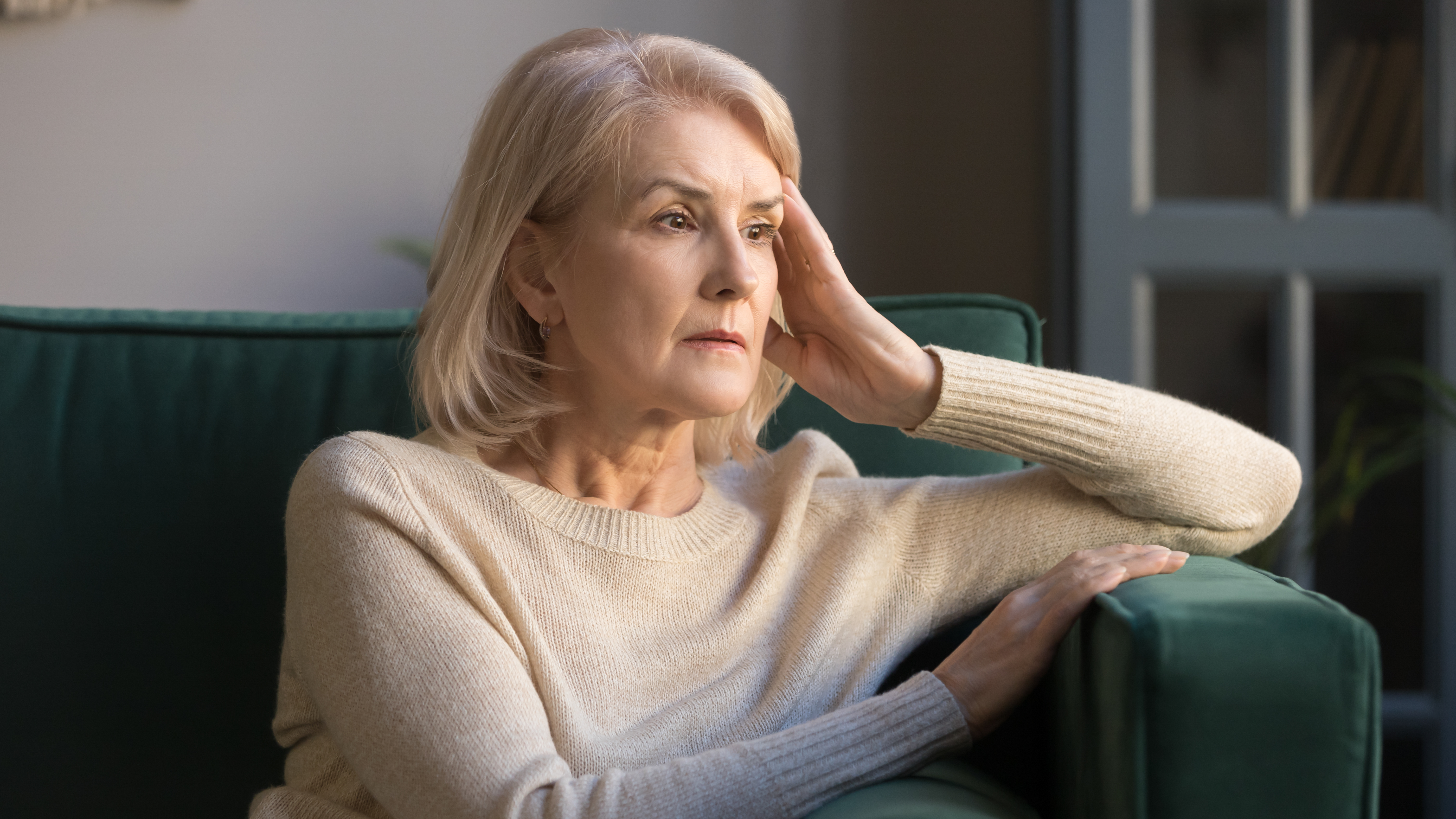 Une femme âgée pensive qui regarde au loin | Source : Shutterstock