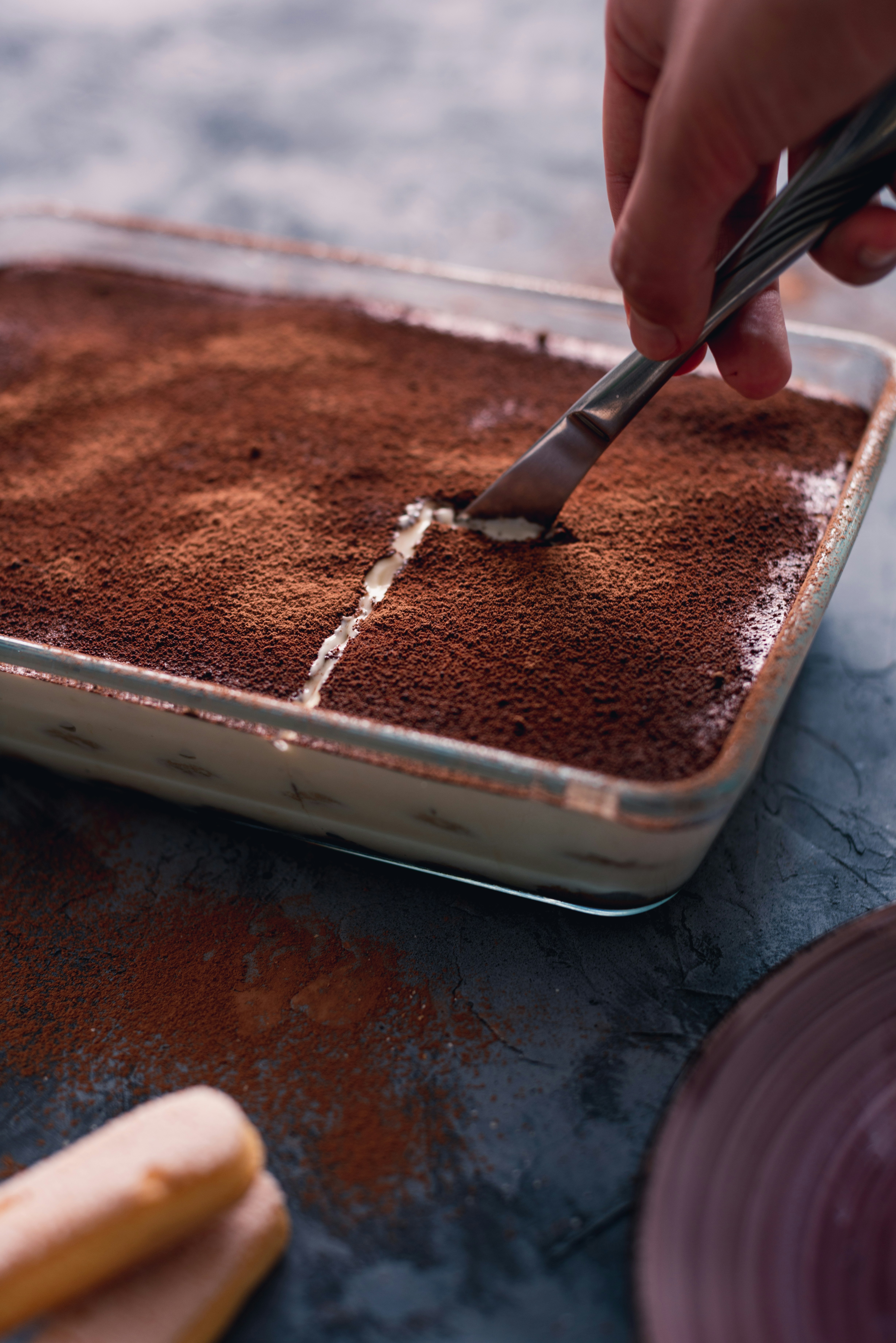 Une personne coupant une tranche de tiramisu | Source : Unsplash