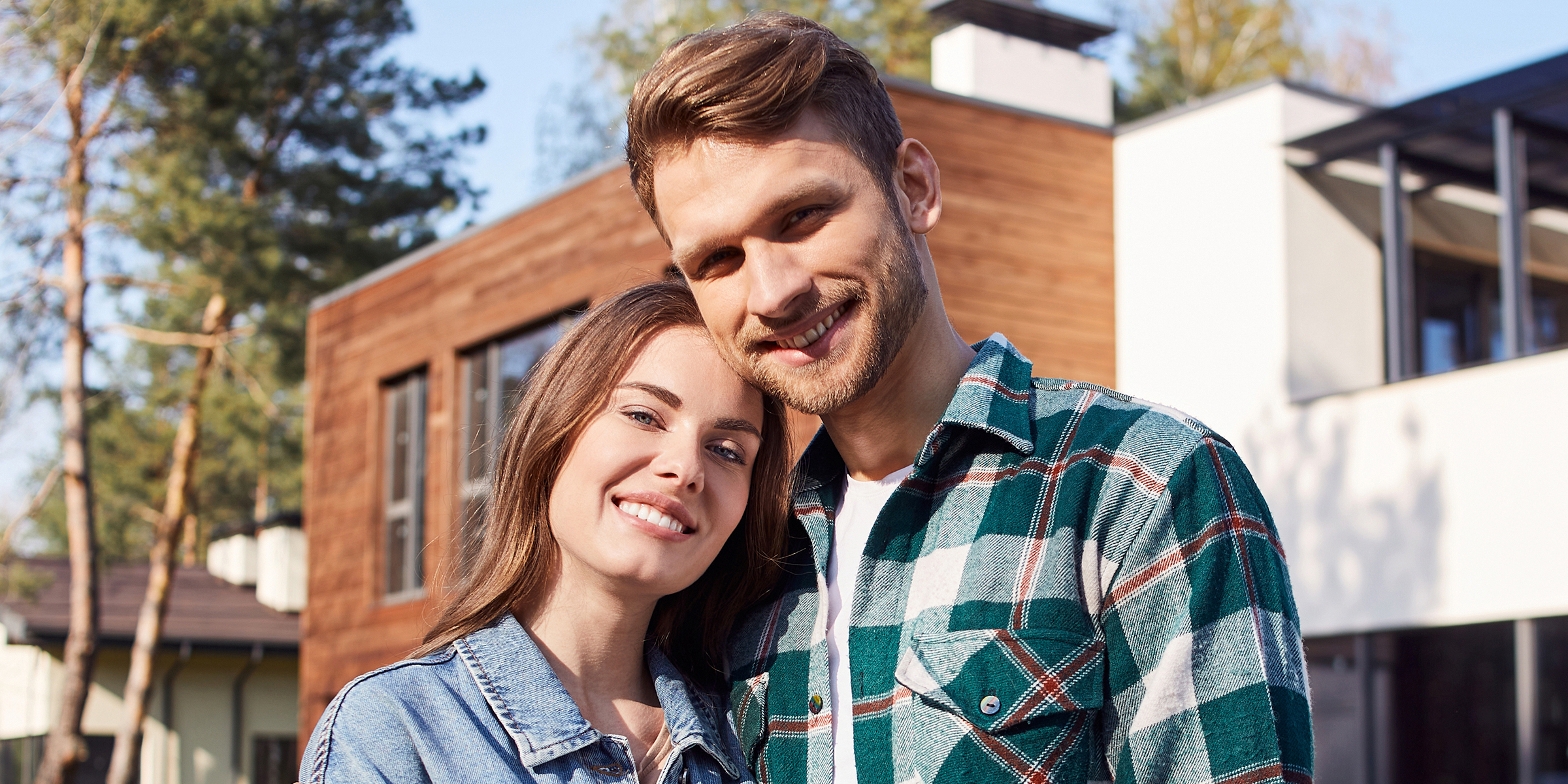 Un couple heureux devant une maison | Source : Shutterstock