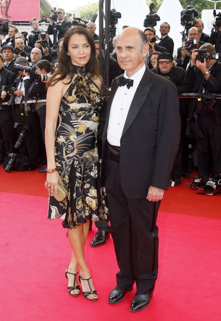 L'acteur et chanteur français Guy Marchand et son épouse Adelina posent en arrivant à la cérémonie d'ouverture et à la projection du film "Blindness" du réalisateur brésilien Fernando Meirelles, lors de la 61e édition du Festival de Cannes, le 14 mai 2008 à Cannes. | Photo : Getty Images