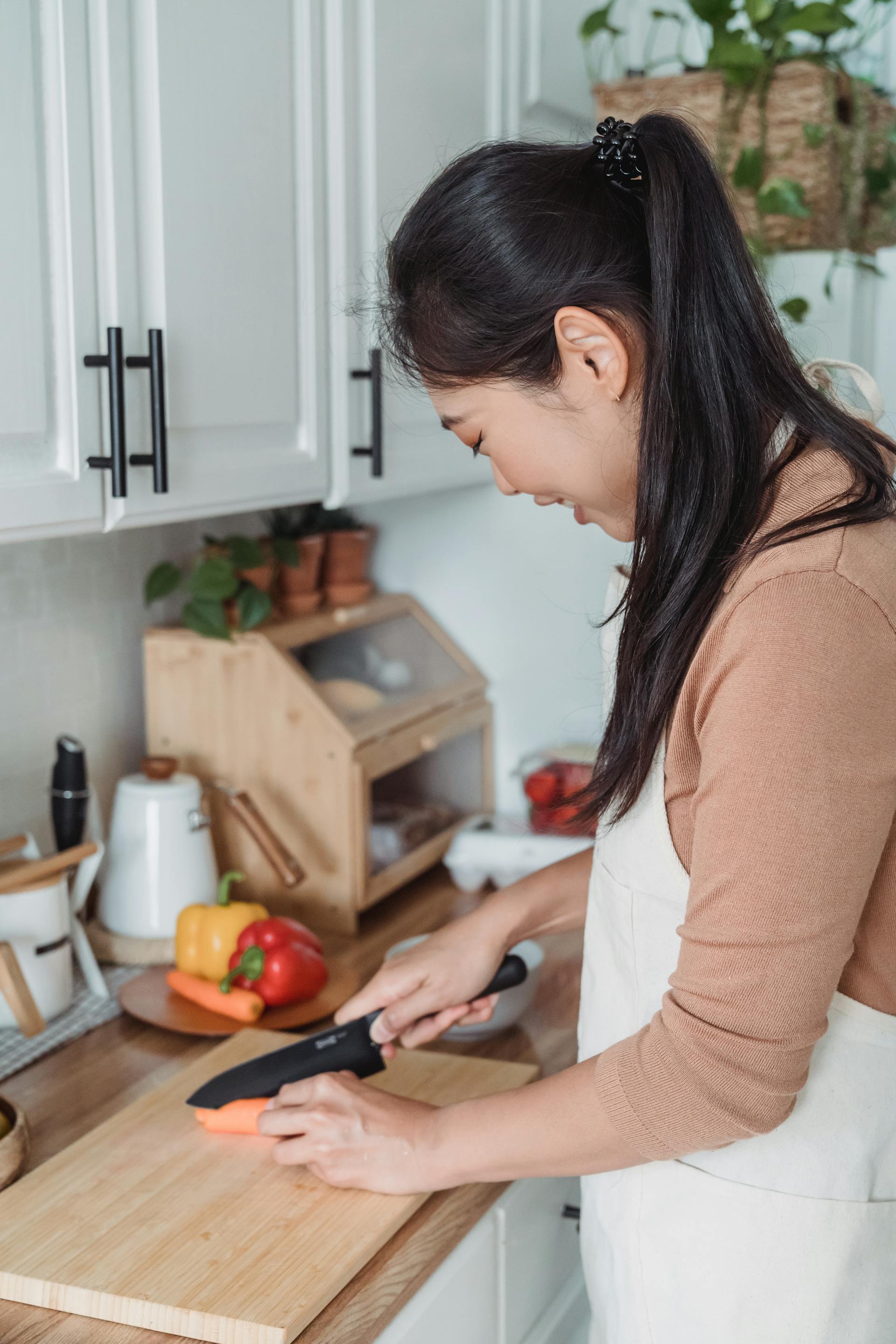 Une femme coupe des carottes | Source : Pexels