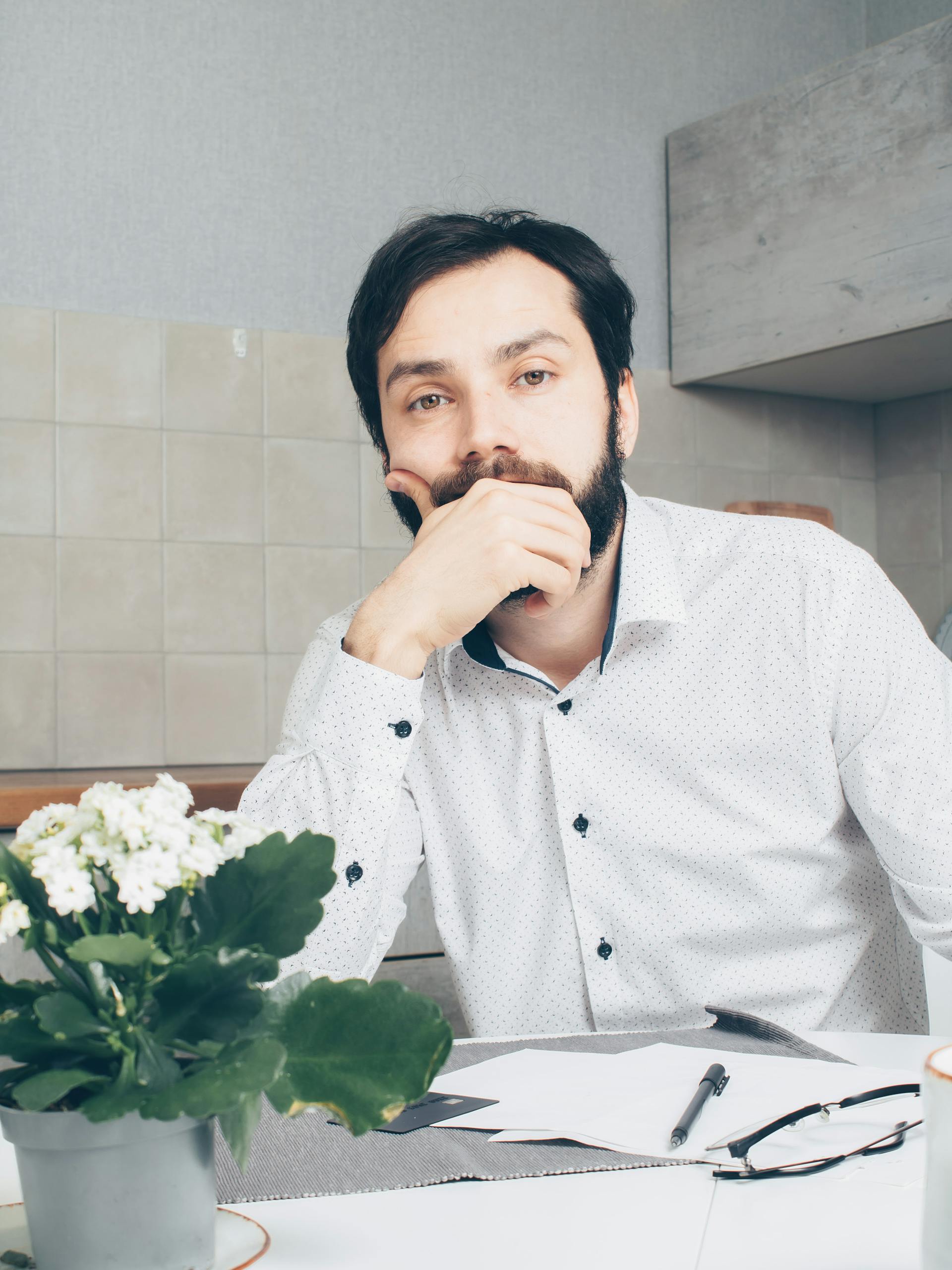 Un homme pensif assis à la table | Source : Pexels