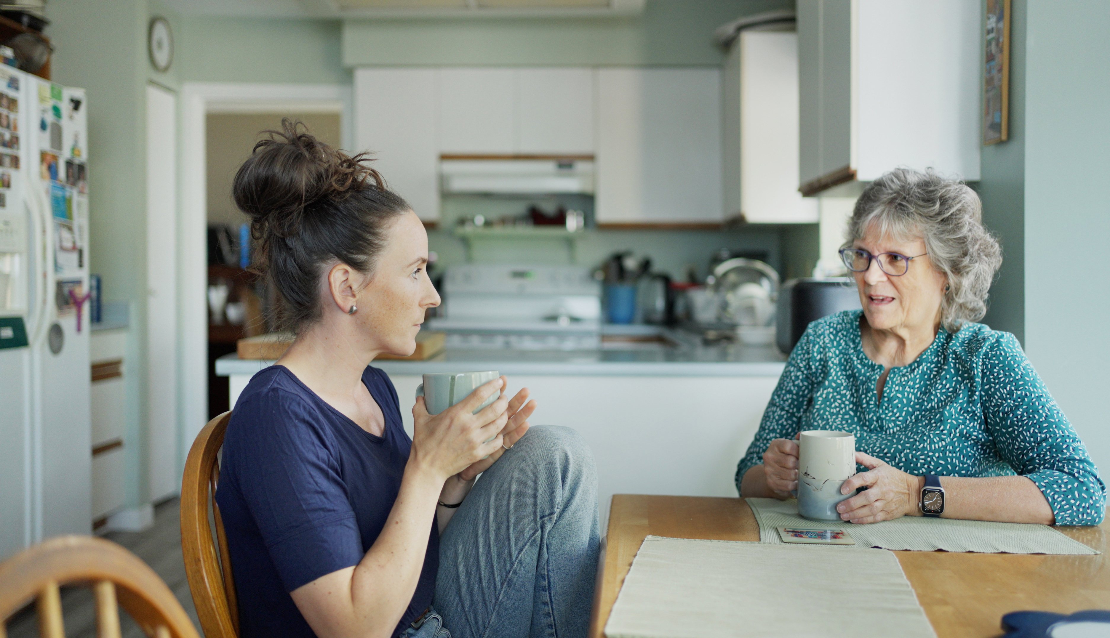 Jeune femme discutant avec sa mère autour d'un thé lors d'une visite | Source : Getty Images