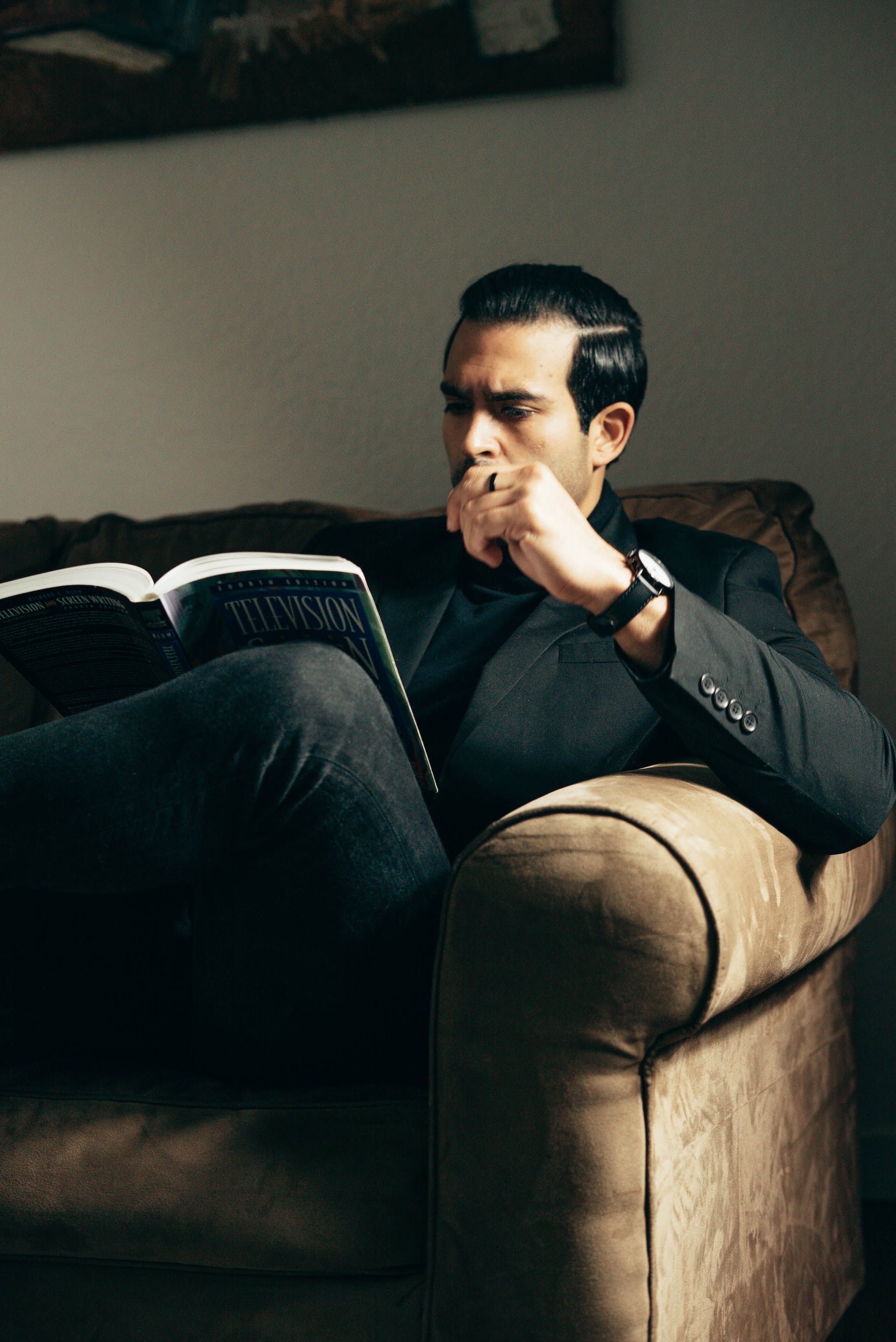 Homme lisant sur le canapé | Source : Pexels