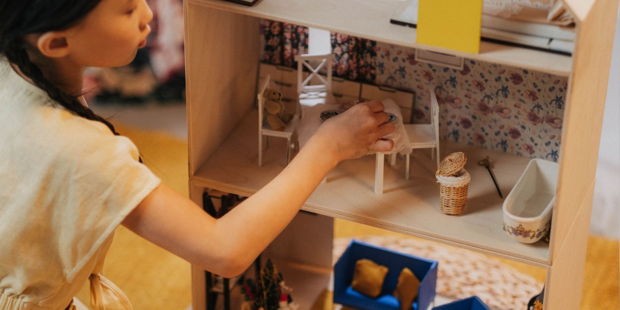 Une petite fille qui range les meubles dans une maison de poupées | Source : Pexels