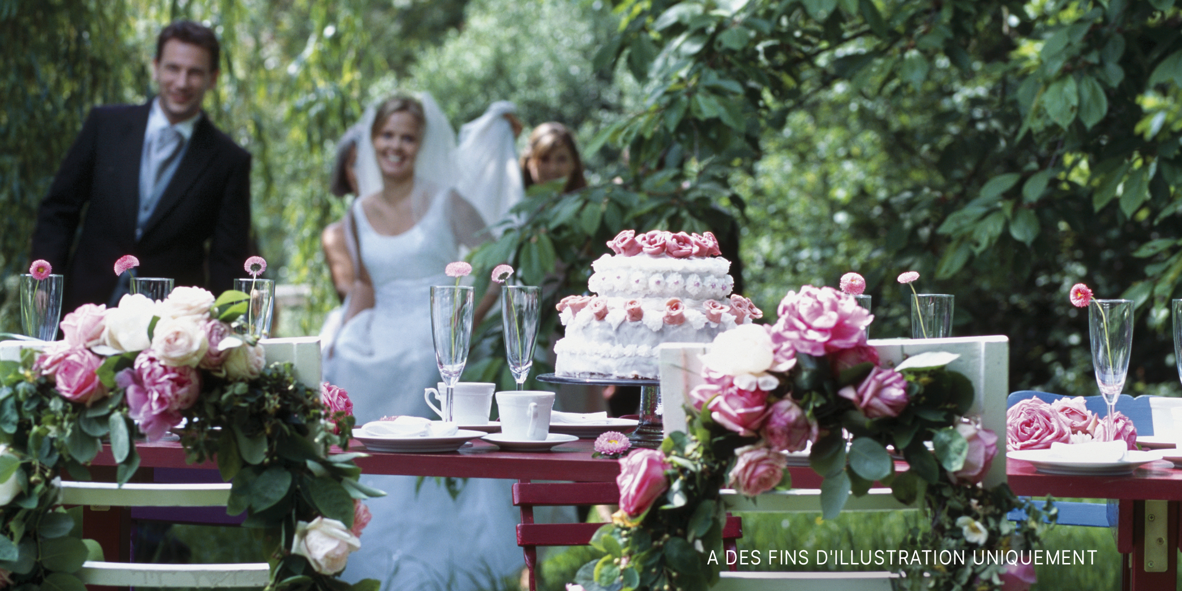 Une mariée et un marié s'approchent pour couper le gâteau lors d'une réception de mariage | Source : Getty Images