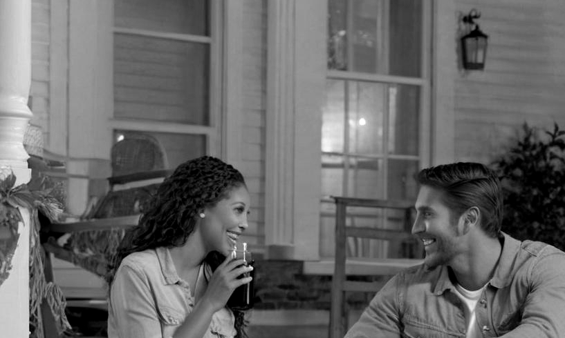 Un couple heureux conversant sous un porche d'entrée | Source : Midjourney