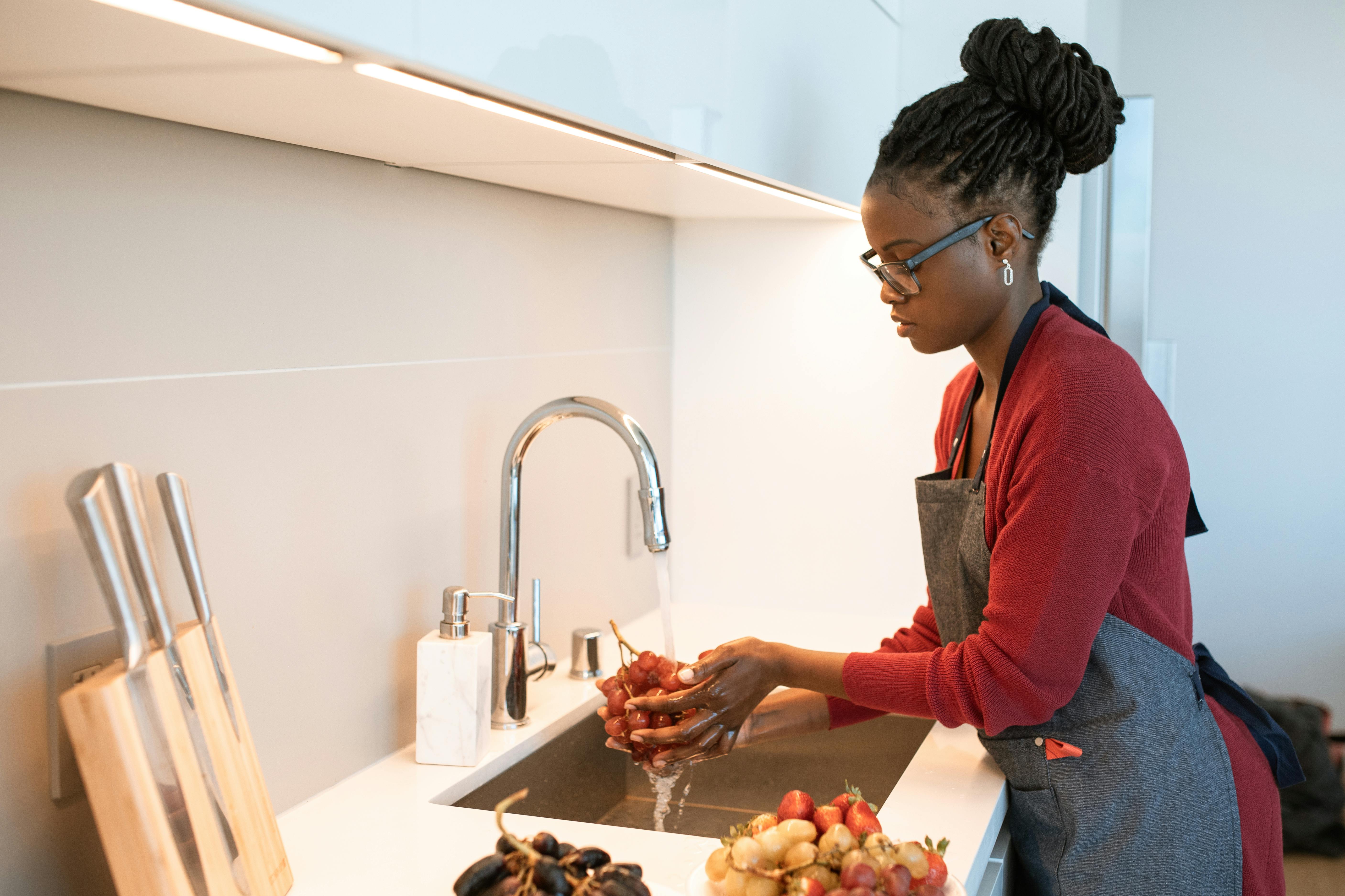 Une femme lave des fruits à la maison | Source : Pexels