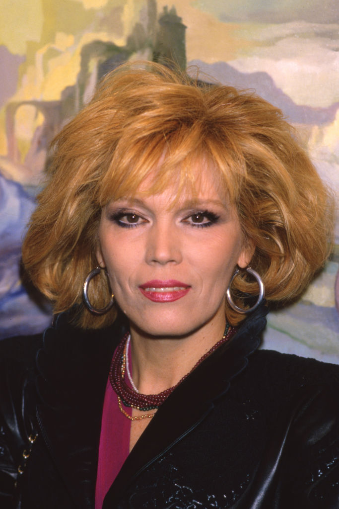 Portrait de l'actrice et peintre Amanda Lear devant ses peintures lors de son exposition le 11 mars 1987. (Photo by Frederic REGLAIN/Gamma-Rapho via Getty Images)