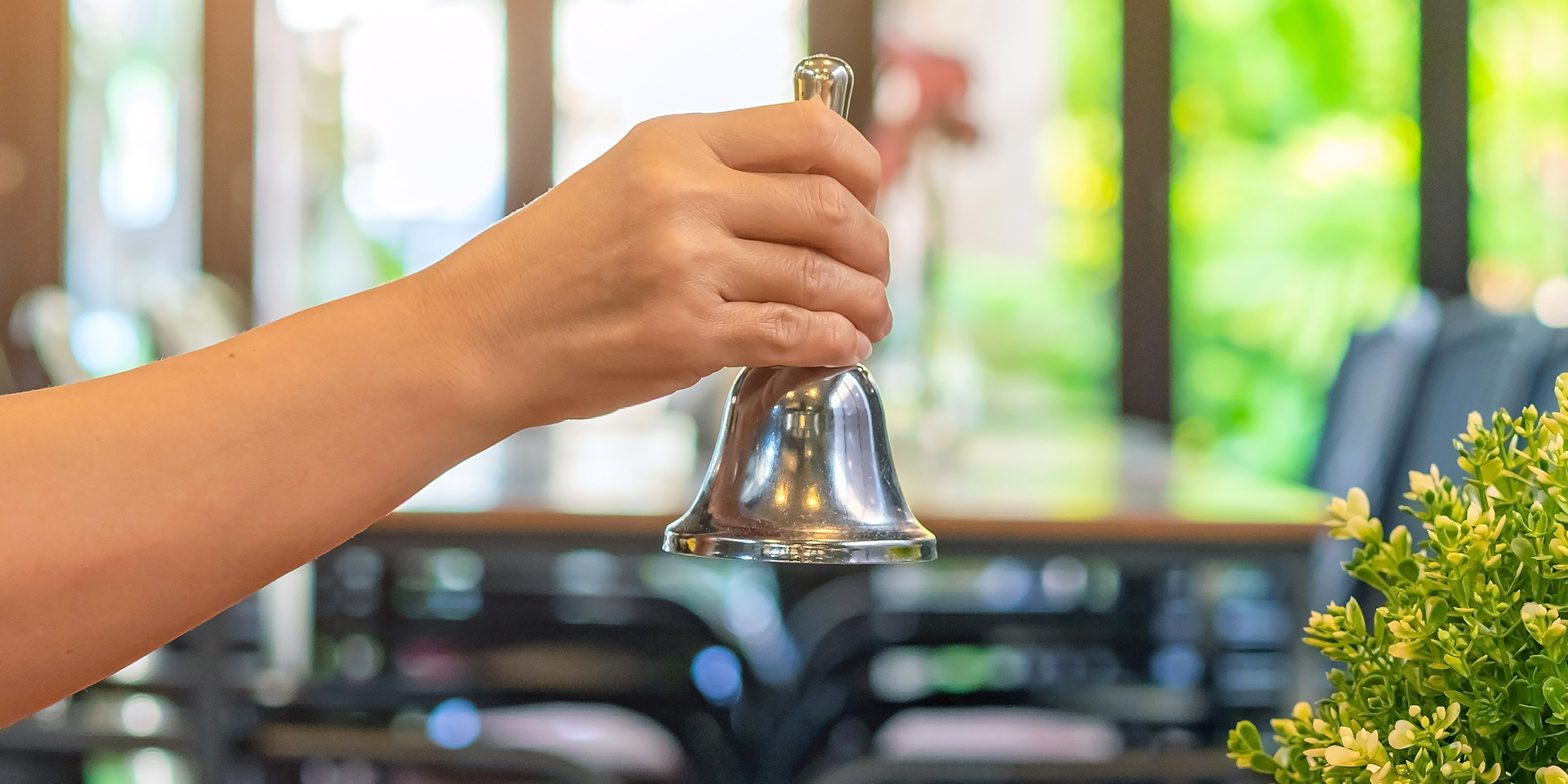 Une femme faisant sonner la cloche de service d'un restaurant | Source : Shutterstock