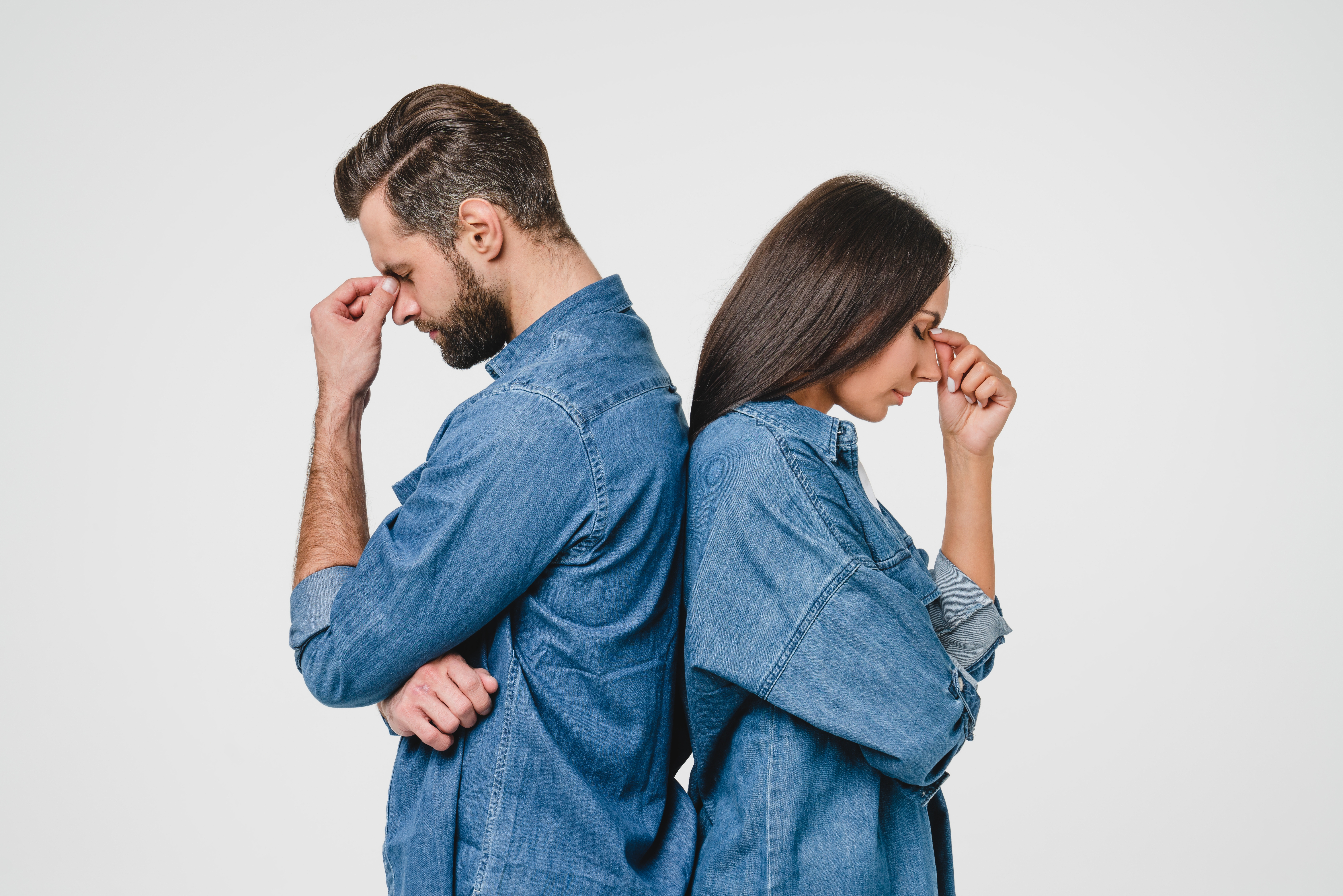 Un homme et une femme contrariés se tenant dos à dos | Source : Shutterstock