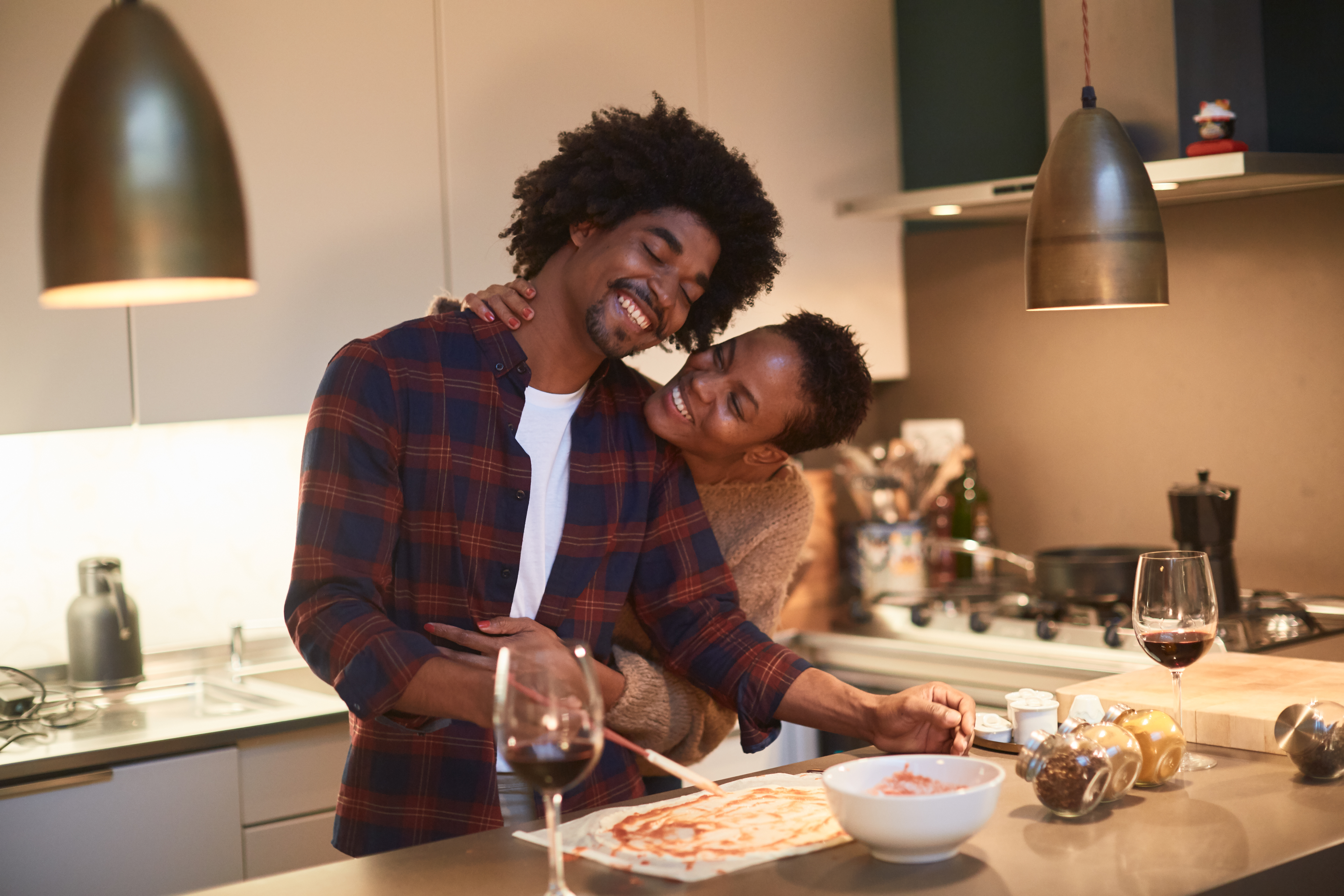 Jeune couple cuisinant à la maison et célébrant la Saint Valentin | Source : Getty Images