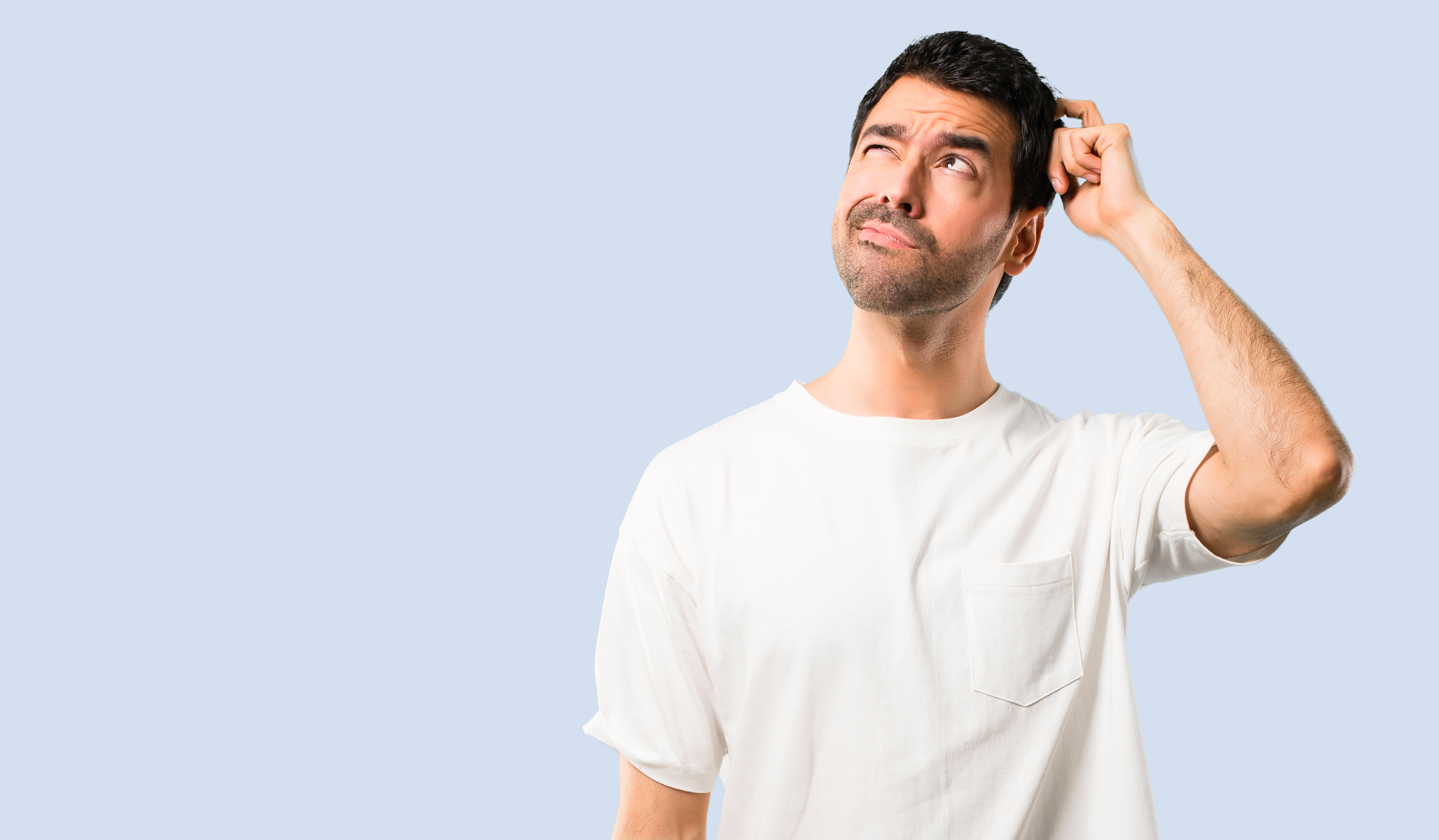 Un homme en chemise blanche qui se gratte la tête | Source : Shutterstock