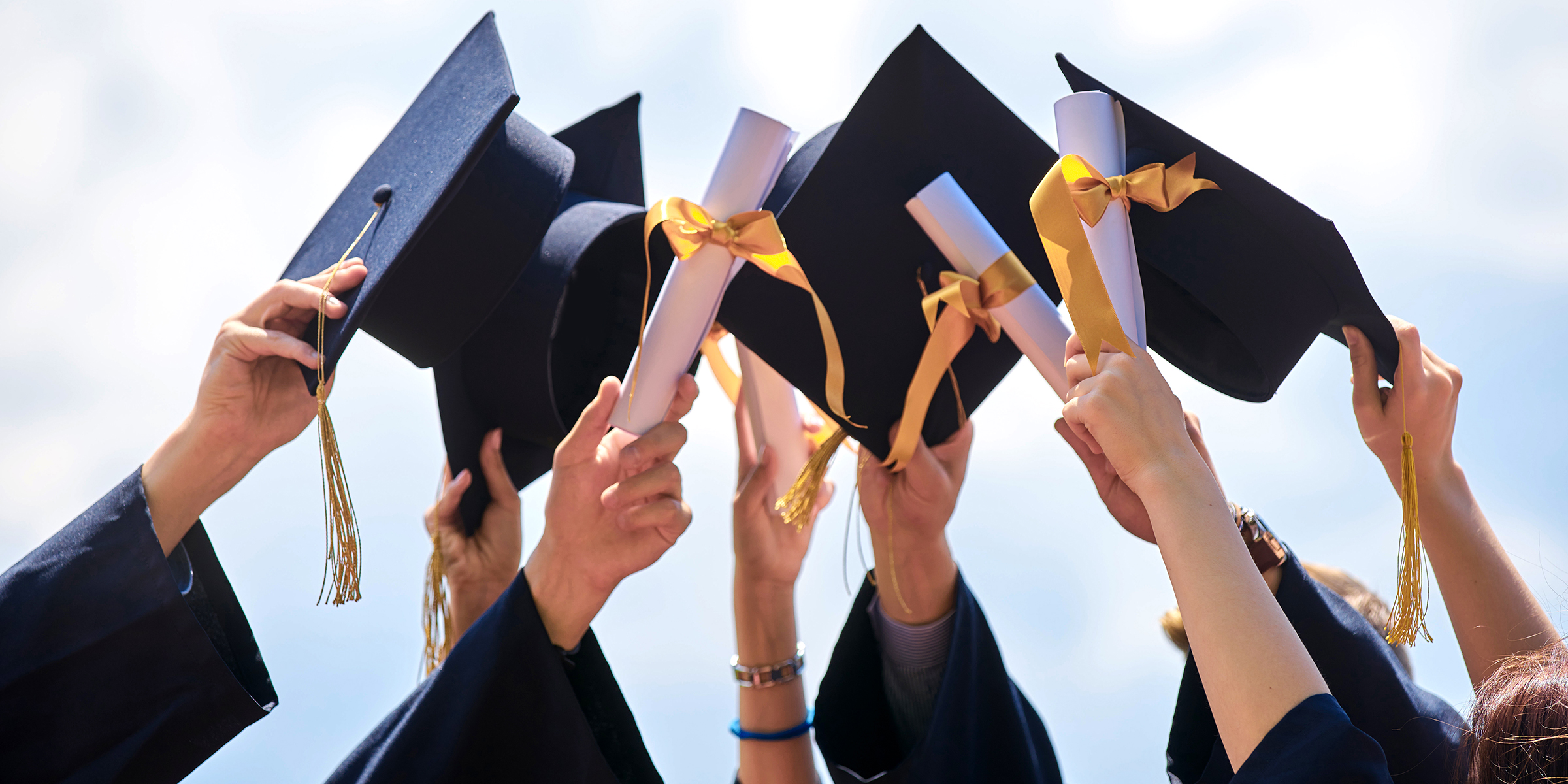 Des étudiants tenant leur chapeau de fin d'études | Source : Shutterstock