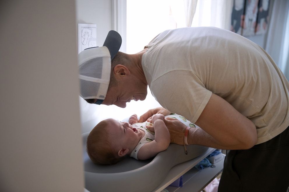 Le père, Charlie Whitmer, change la couche de son fils. | Source : Getty Images