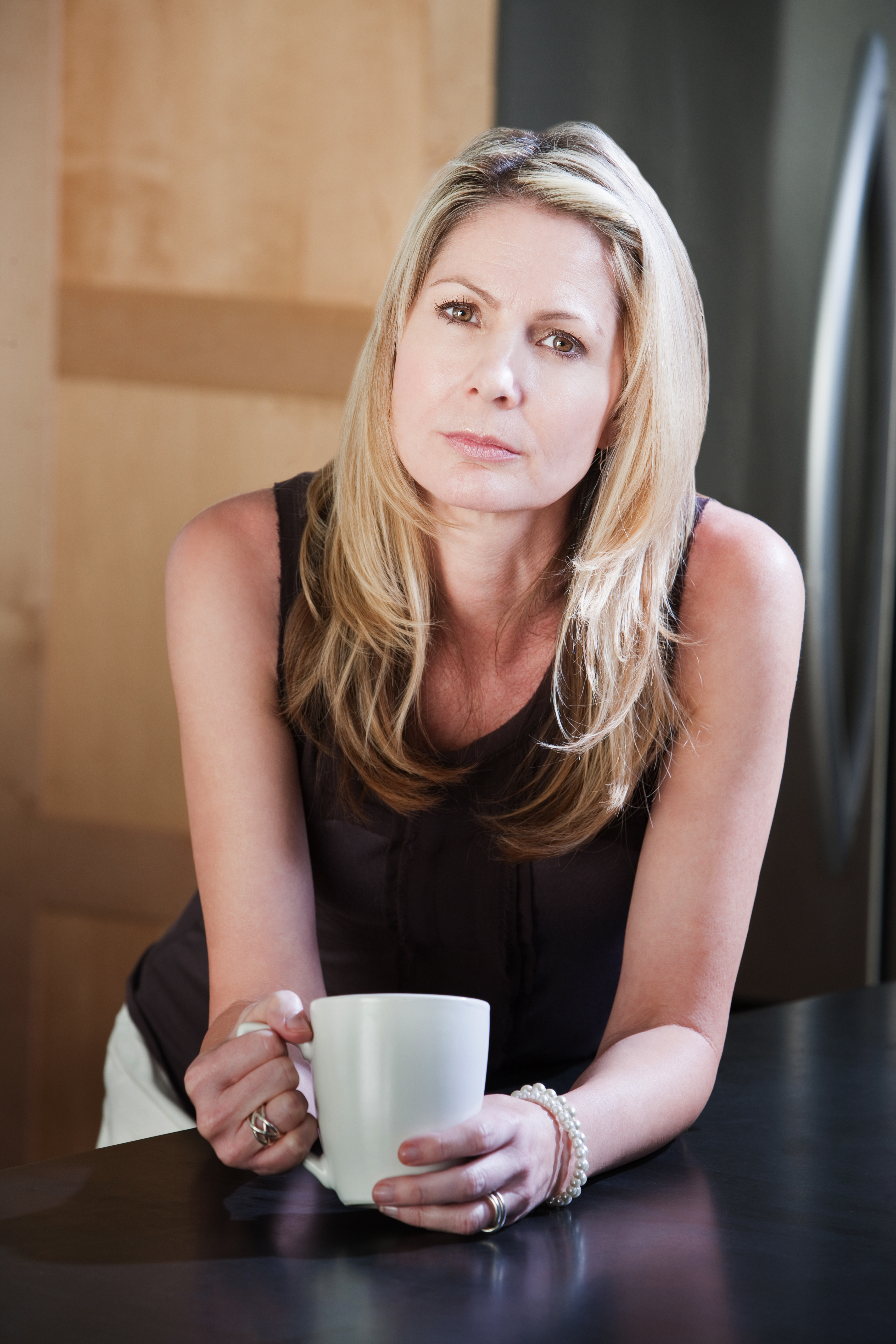 Une femme d'âge moyen tenant une tasse à café | Source : Shutterstock
