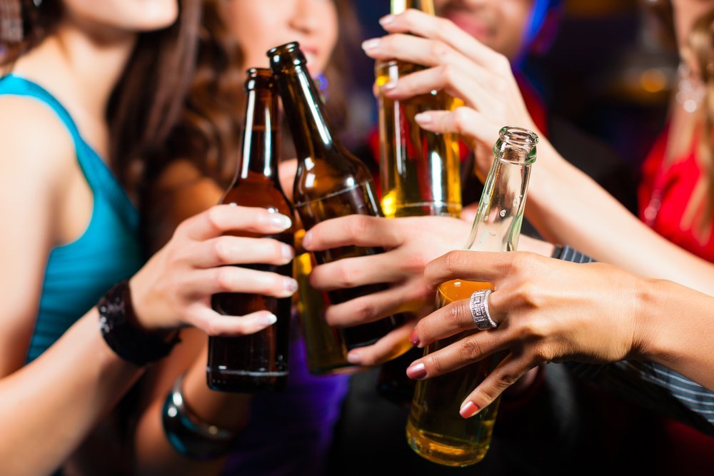 Groupe de personnes - hommes et femmes - buvant de la bière dans un pub ou un bar. | Shutterstock