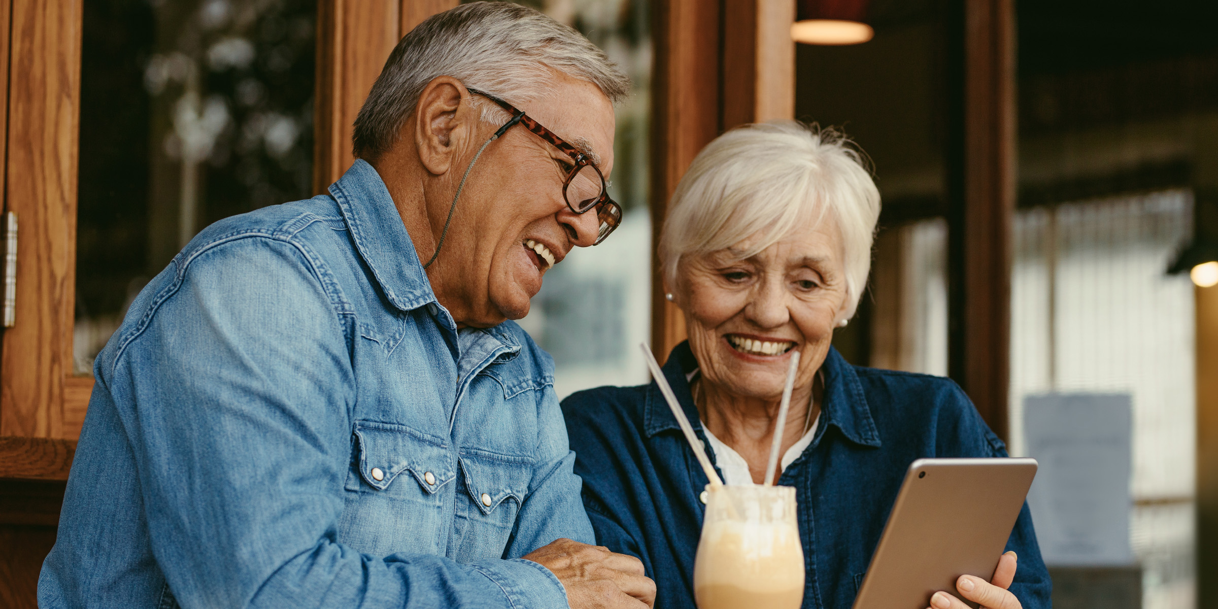 Un couple de personnes âgées heureuses regardant une tablette | Source : Shutterstock