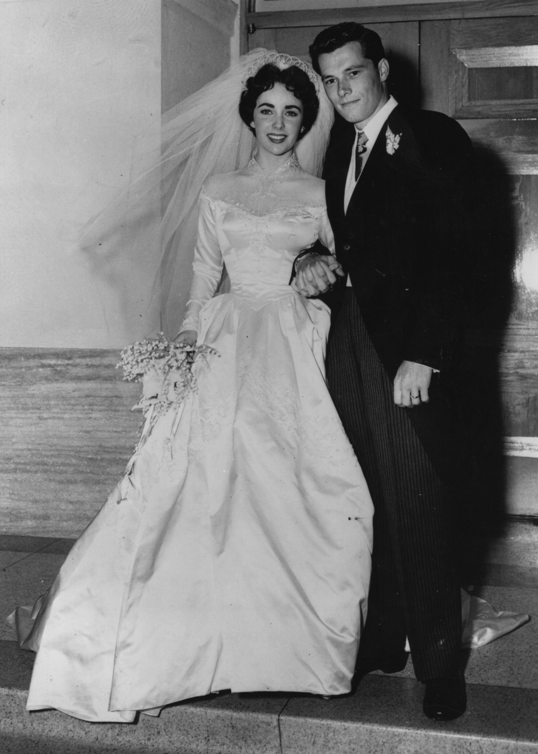 Elizabeth Taylor et son premier mari, l'hôtelier Conrad Hilton, posent après leur mariage le 13 mai 1950 à Hollywood | Source : Getty Images