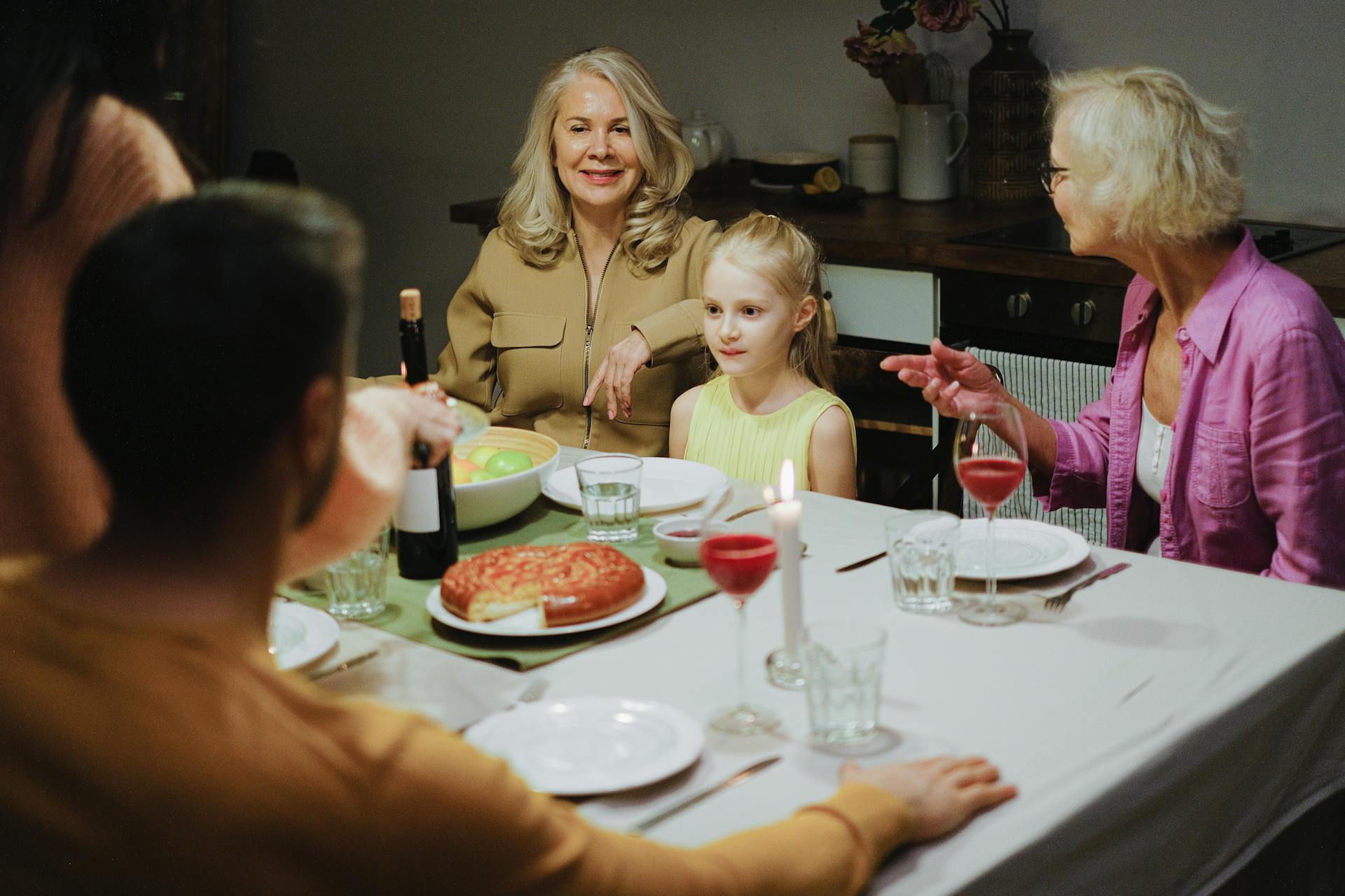 Une famille assise ensemble pour le dîner | Source : Pexels