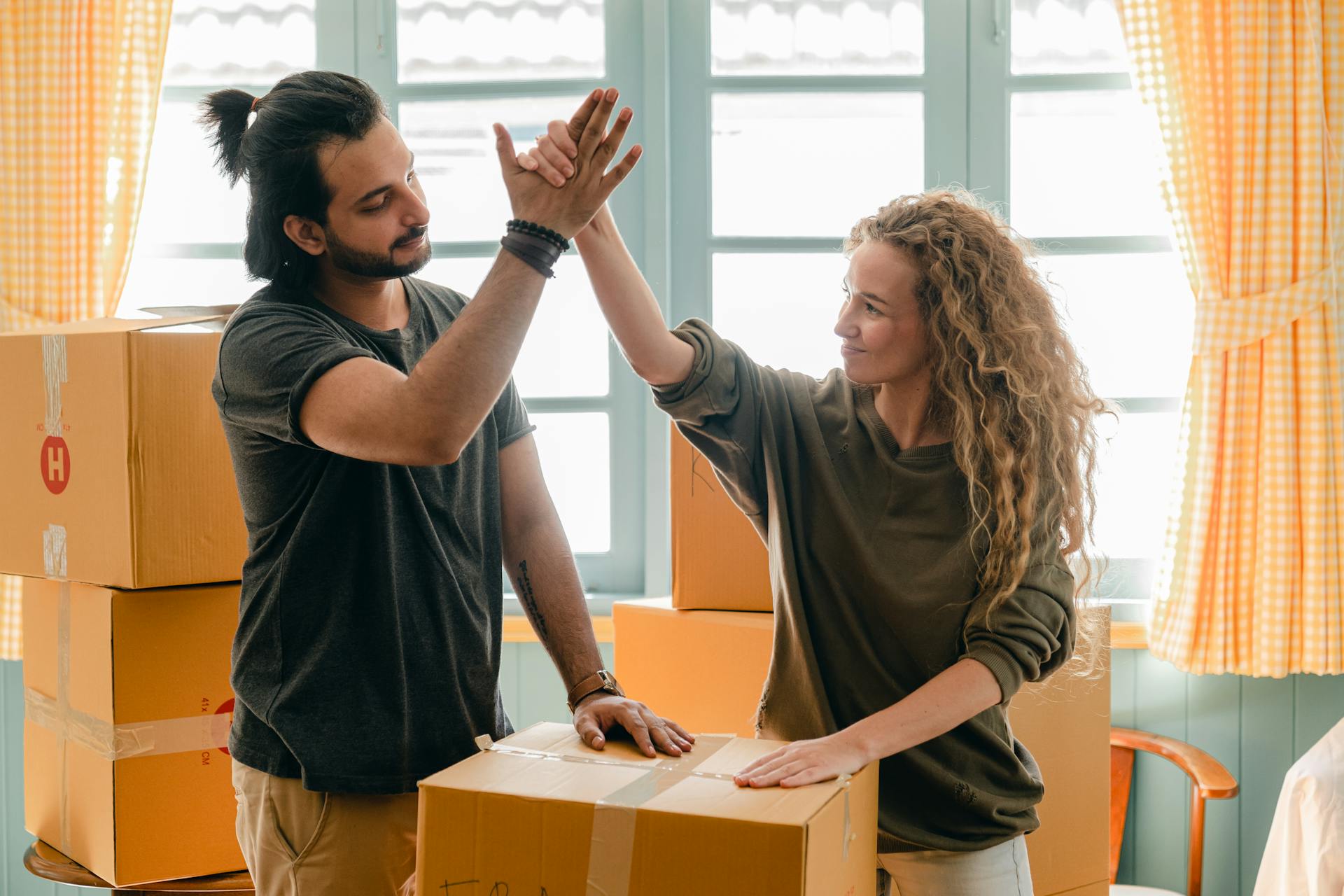 Un couple déballe des cartons dans leur nouvelle maison | Source : Pexels