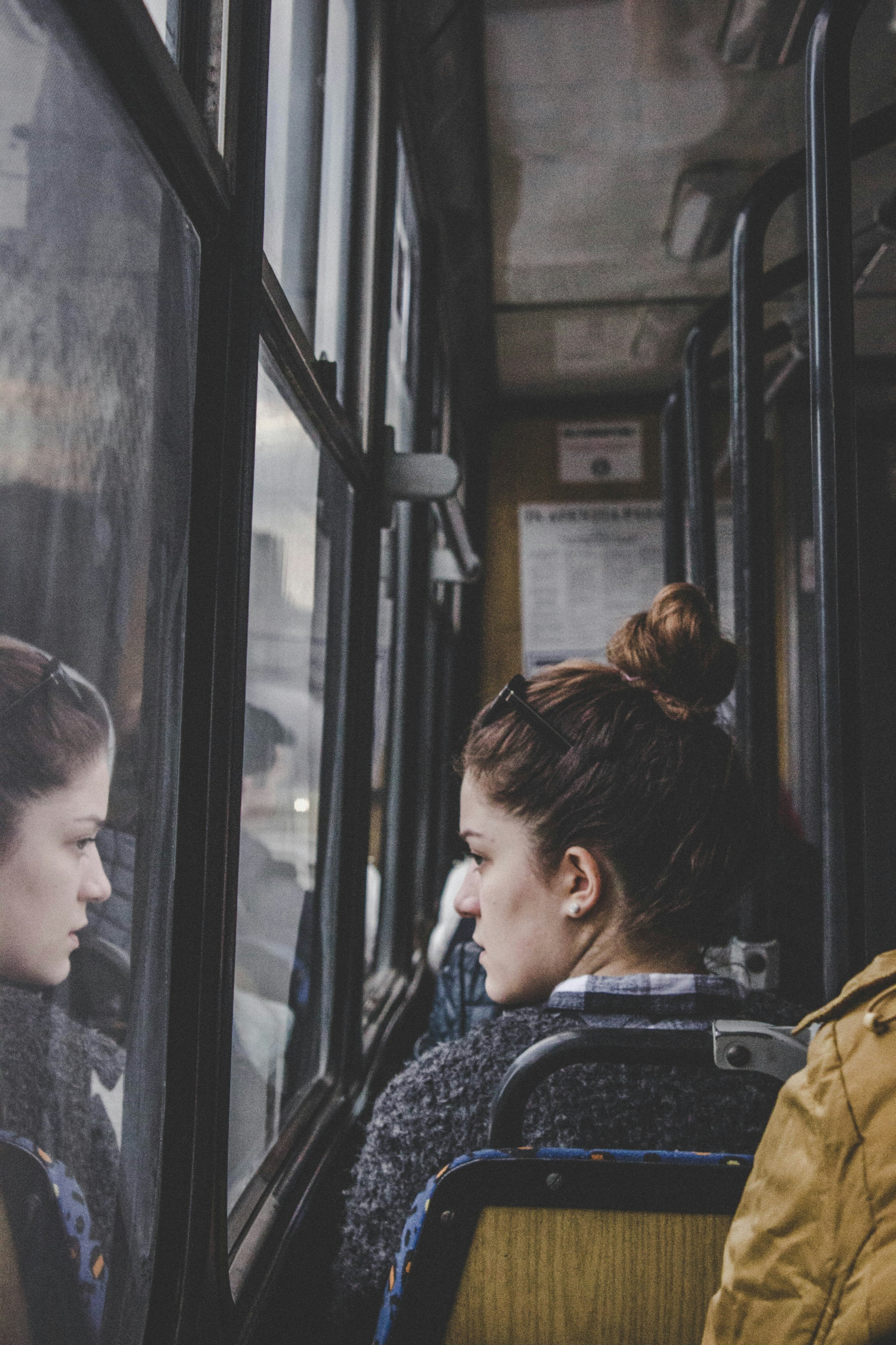 Une femme regardant par la fenêtre d'un bus | Source : Unsplash