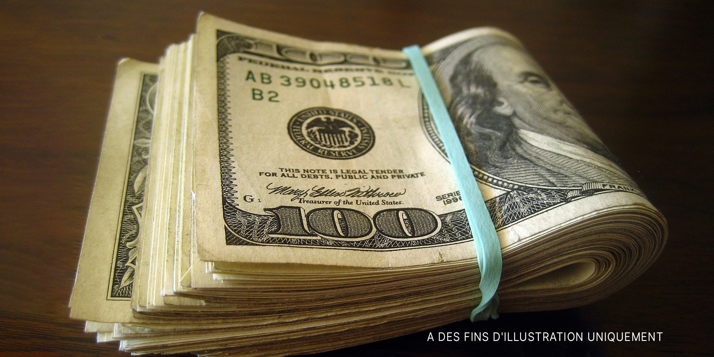 Source : Flickr / 401(K) 2013 (CC BY-SA 2.0) | Pile de billets de cent dollars pliés et attachés avec un élastique.
