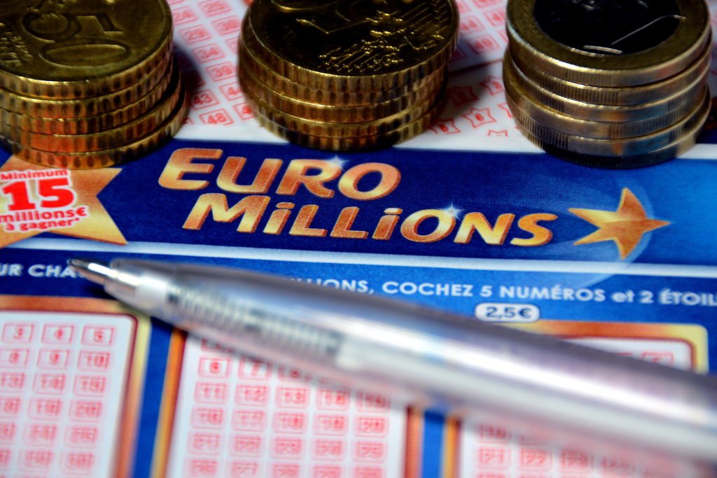 Un stylo et des pièces d'euros sur les billets de l'Euromillions | Photo : Getty Images