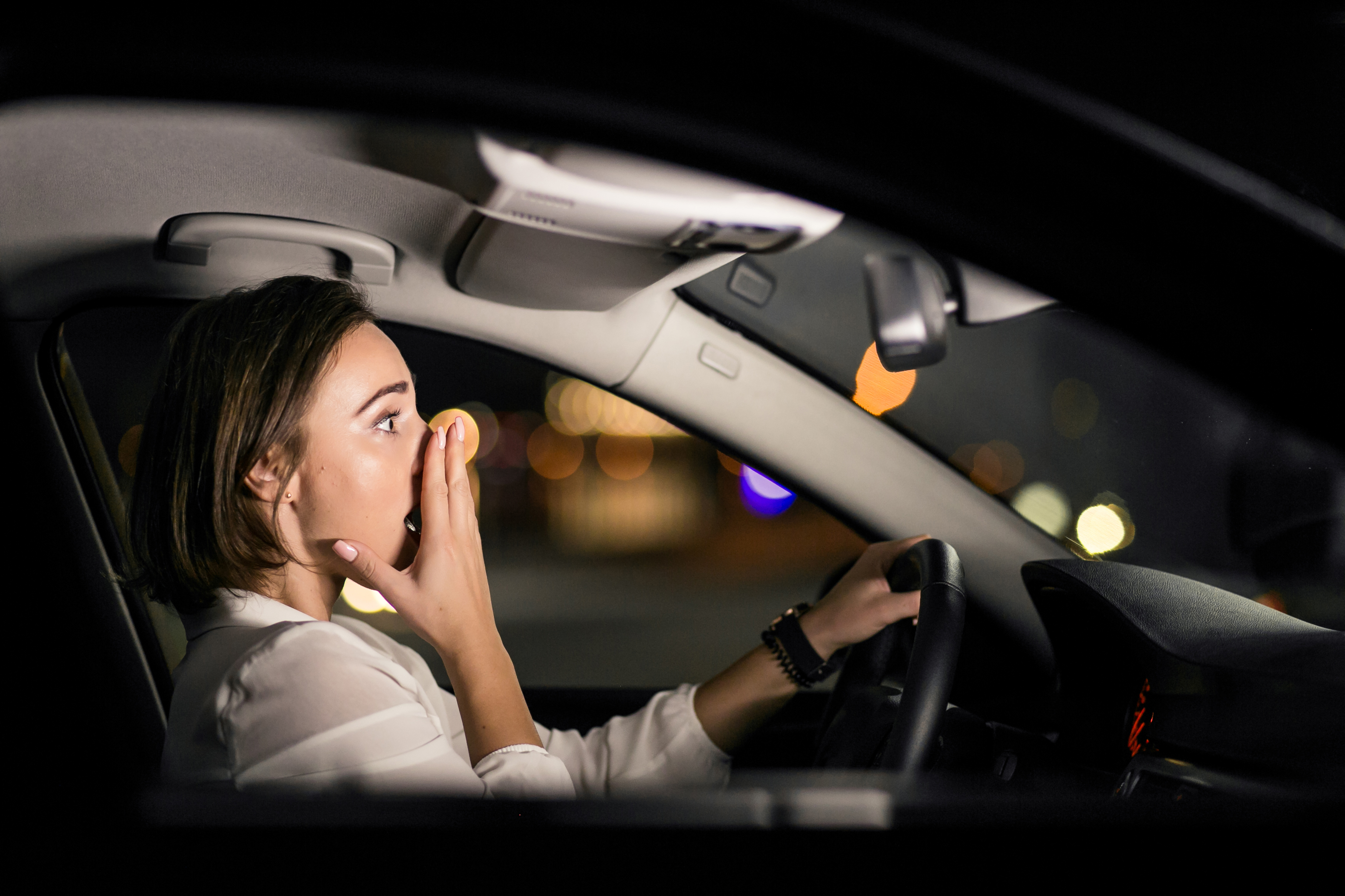 Prise de vue nocturne d'une femme choquée au volant d'une voiture | Source : Freepik