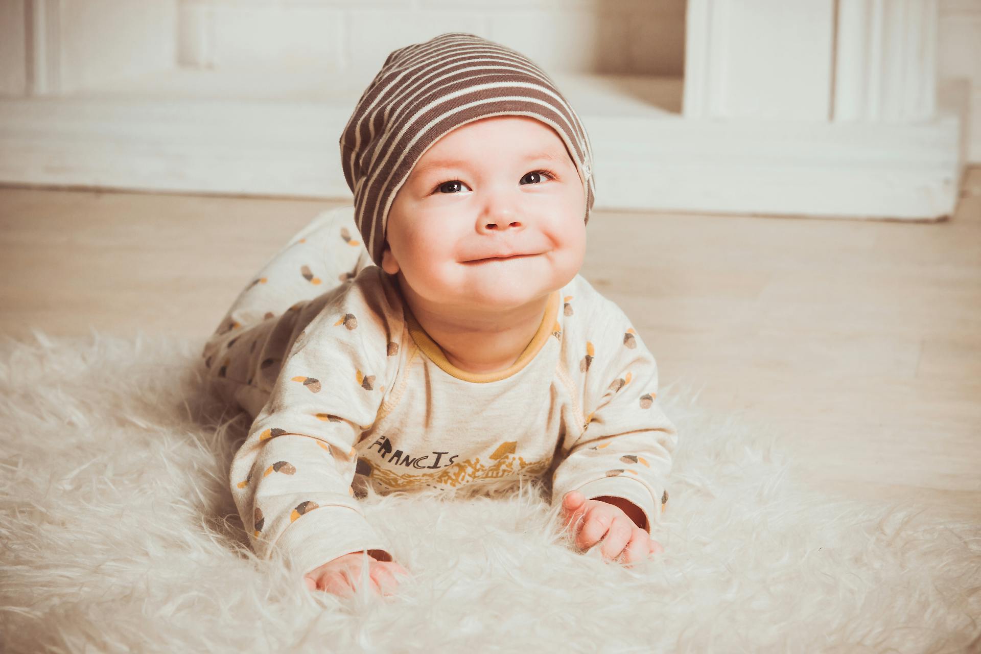 Un bébé rampant sur un tapis de fourrure | Source : Pexels