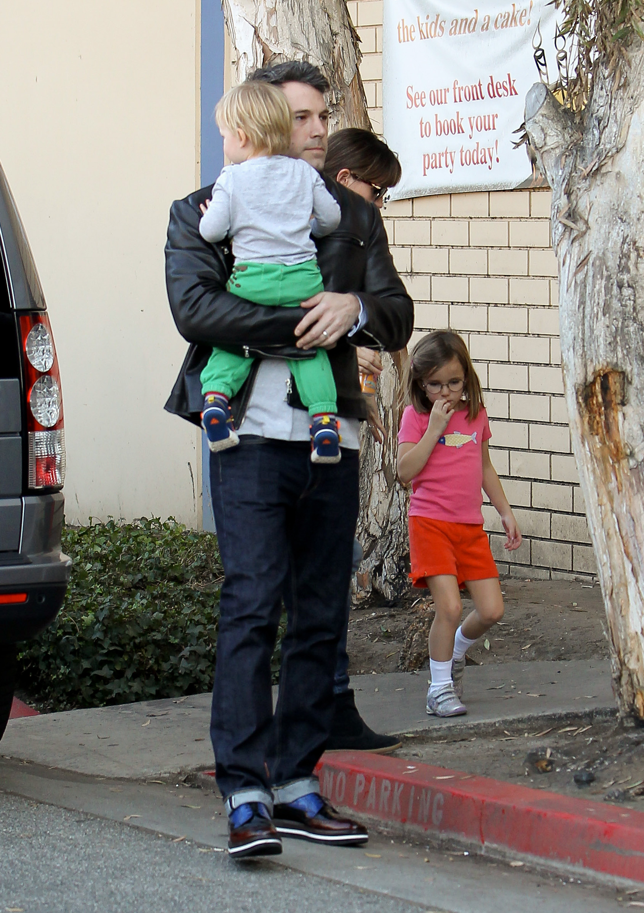 Ben Affleck marche avec Samuel Garner Affleck près de sa poitrine tandis que Jennifer Garner marche derrière avec leur fille Seraphina Affleck le 9 novembre 2013 à Los Angeles, en Californie. | Source : Getty Images