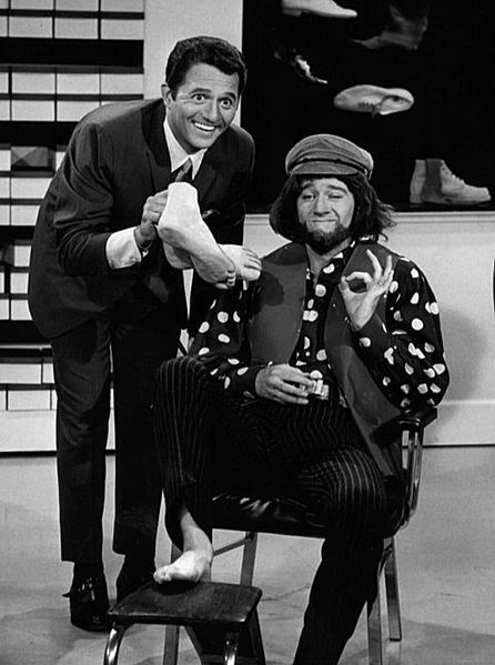 George Carlin (à droite, en costume) et le chanteur Buddy Greco (à gauche) dans un sketch de l'émission de télévision de remplacement de l'été "Away We Go". | Source : Wikimedia Commons