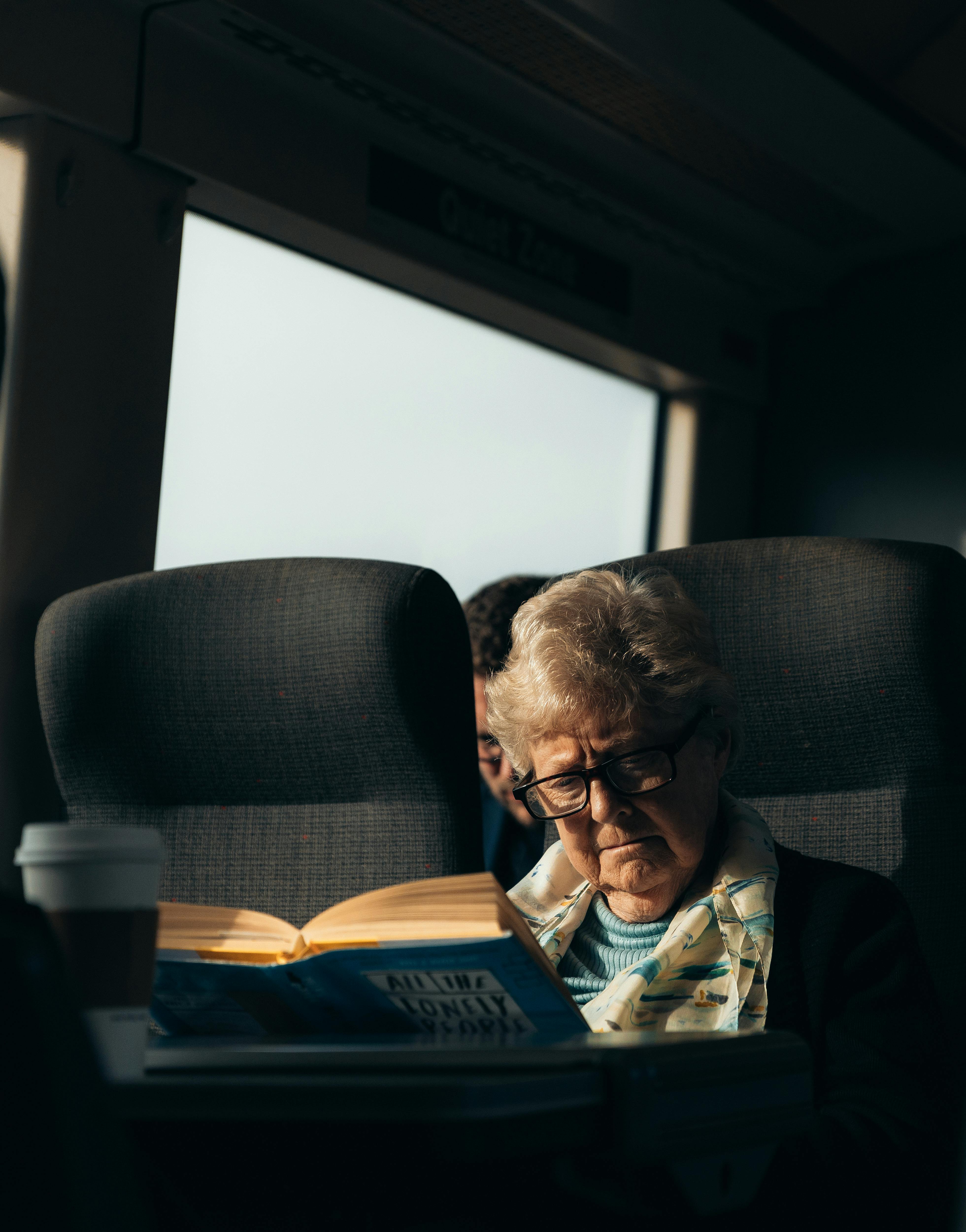 Une femme âgée lisant un livre pendant qu'elle voyage en train | Source : Pexels