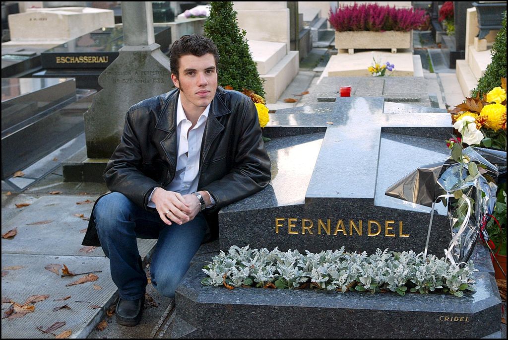  le petit-fils de Fernandel, Vincent, sur la tombe de son grand-père au cimetière de Passy à Paris, France, le 1er novembre 2002. | Photo : Getty Images