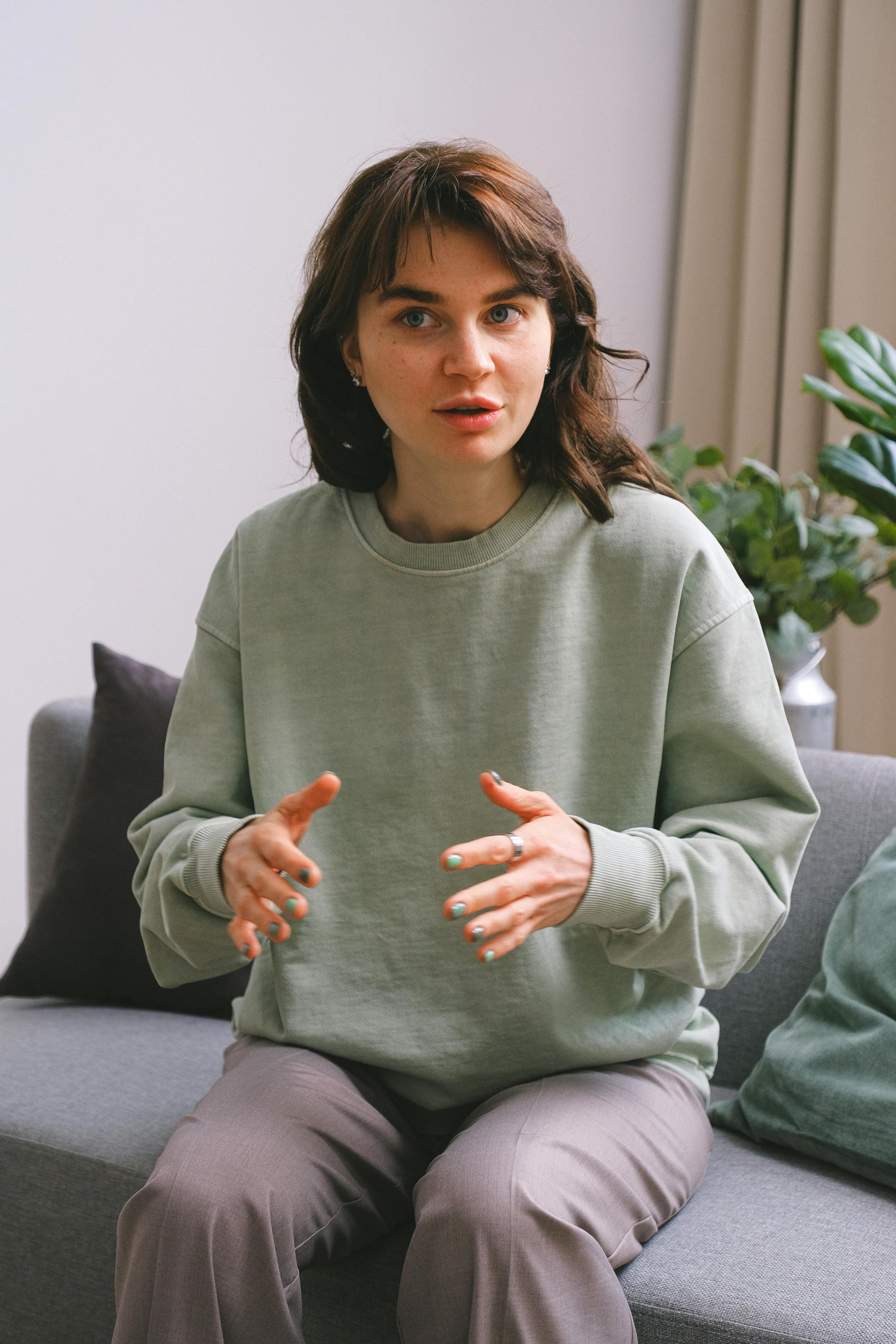 Une jeune femme qui s'exprime en faisant des gestes avec ses mains | Source : Pexels