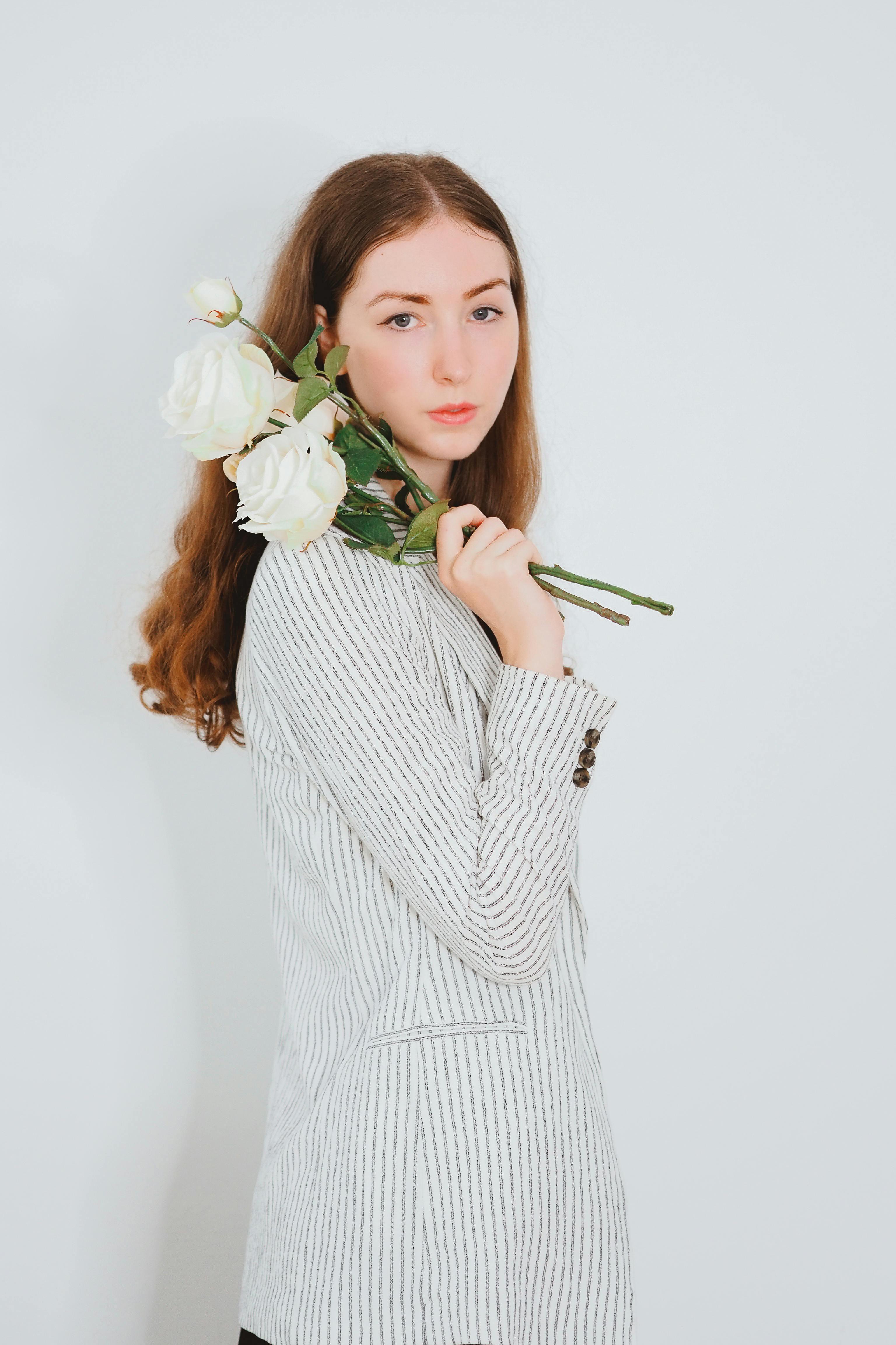 Une femme tenant des roses blanches | Source : Pexels