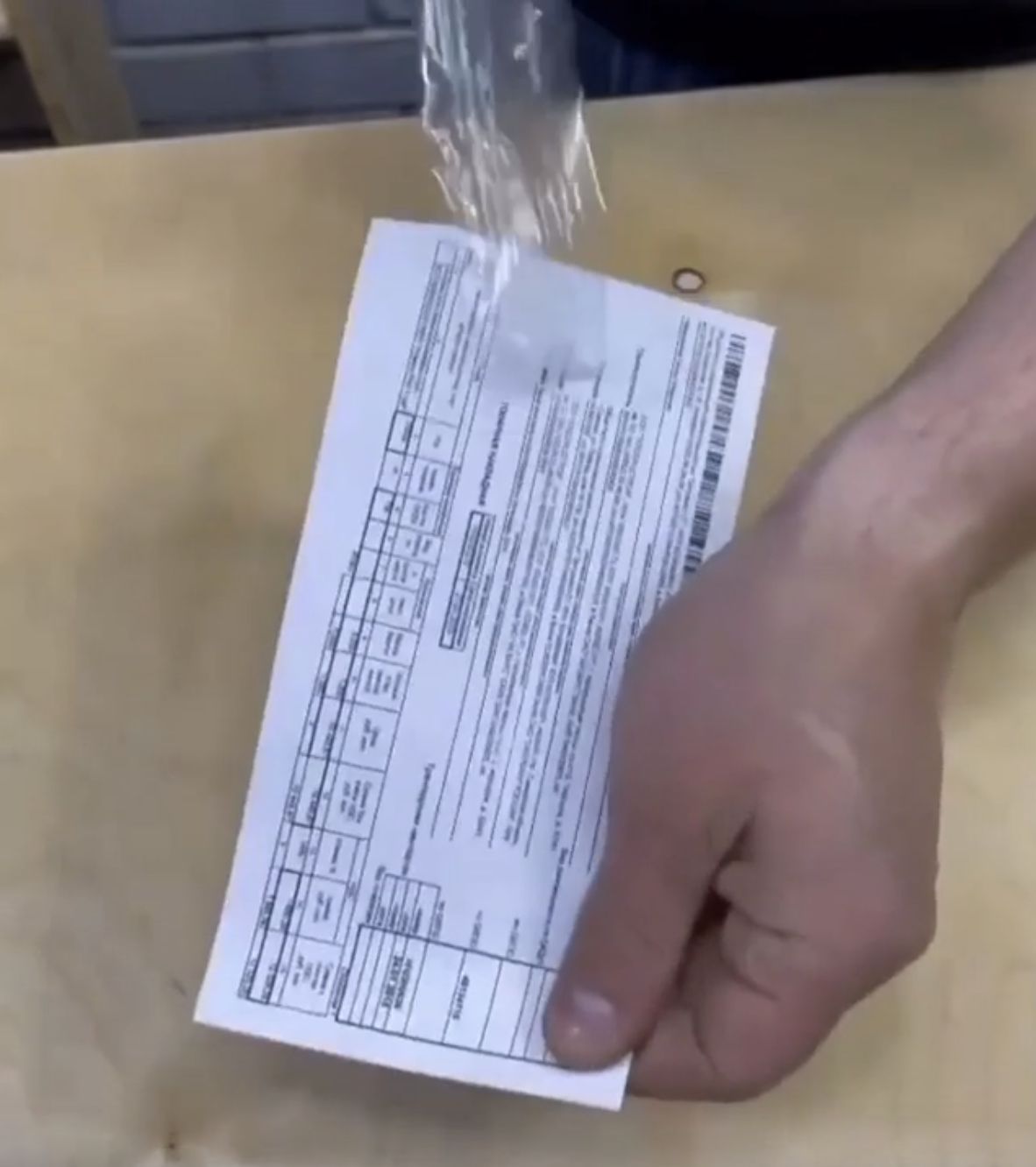 Close-up of a person easily removing clear tape from a document, as seen in a video shared online | Source: Reddit/r3dl3mon