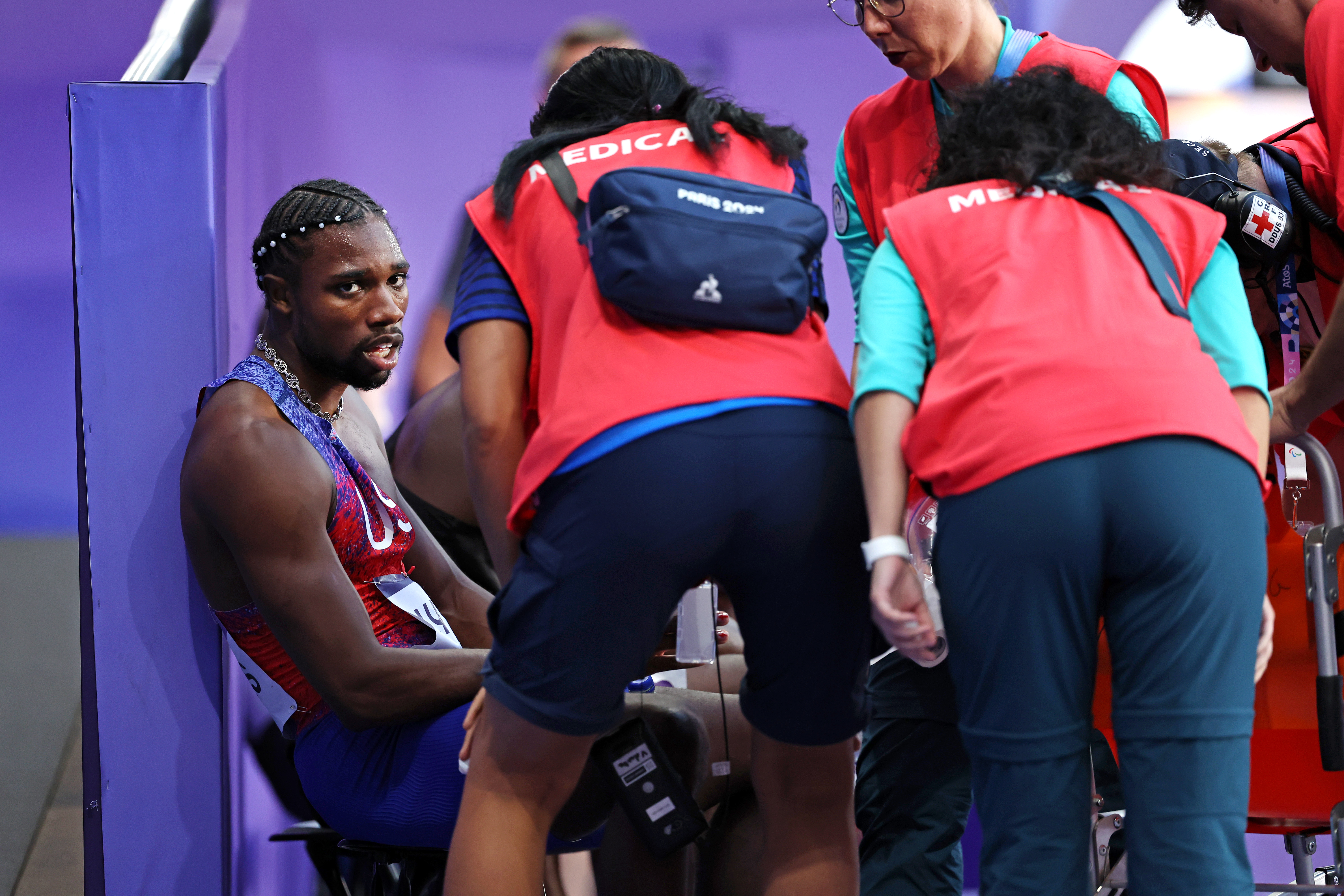 Noah Lyles de l'équipe des États-Unis avec le personnel médical après avoir participé à la finale du 200 m masculin aux Jeux olympiques de Paris le 8 août 2024 | Source : Getty Images