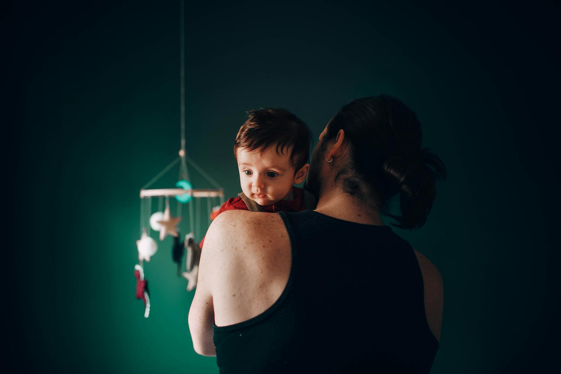Un homme berce un bébé dans une chambre d'enfant | Source : Pexels