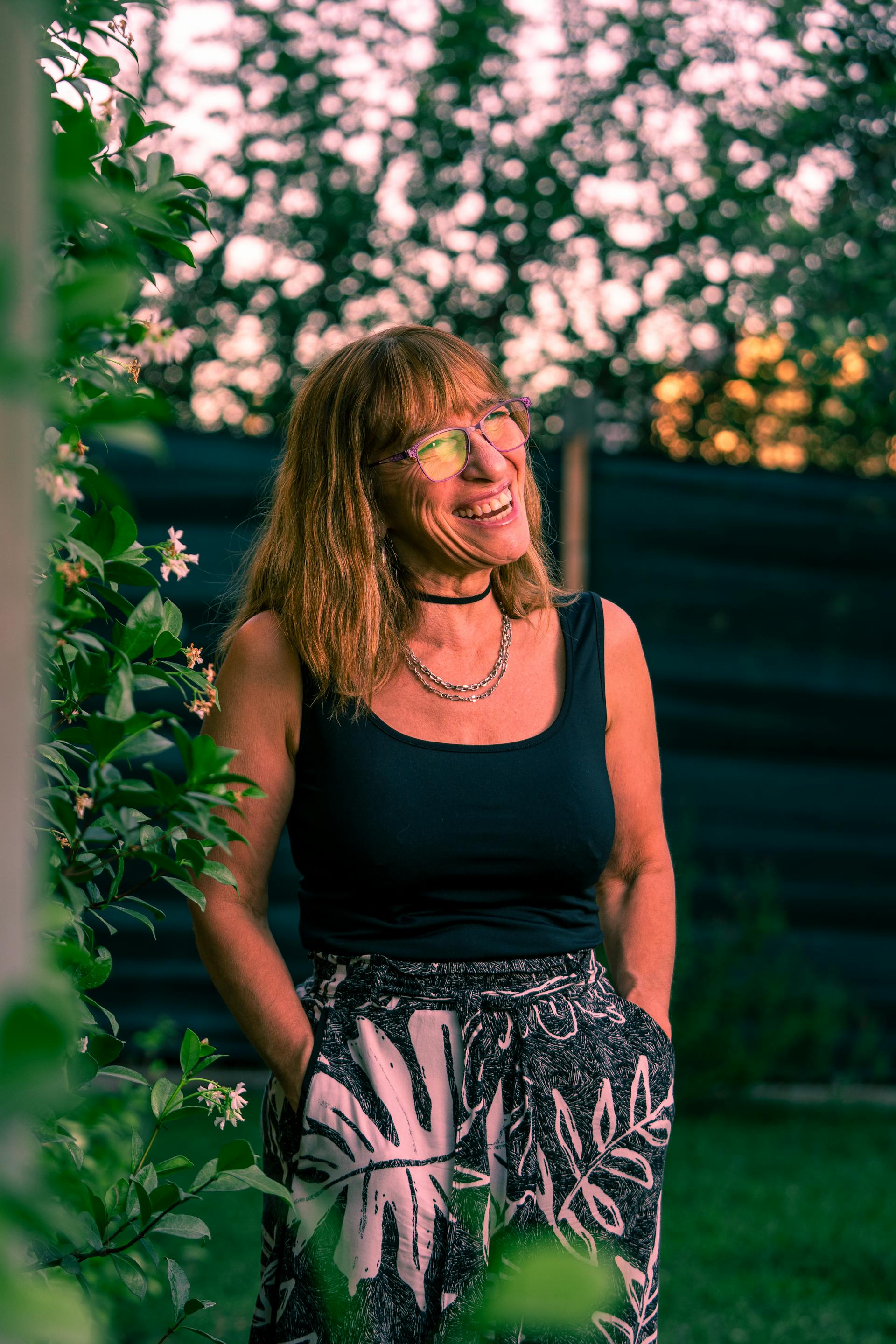 Une femme souriante debout dans le jardin | Source : Pexels