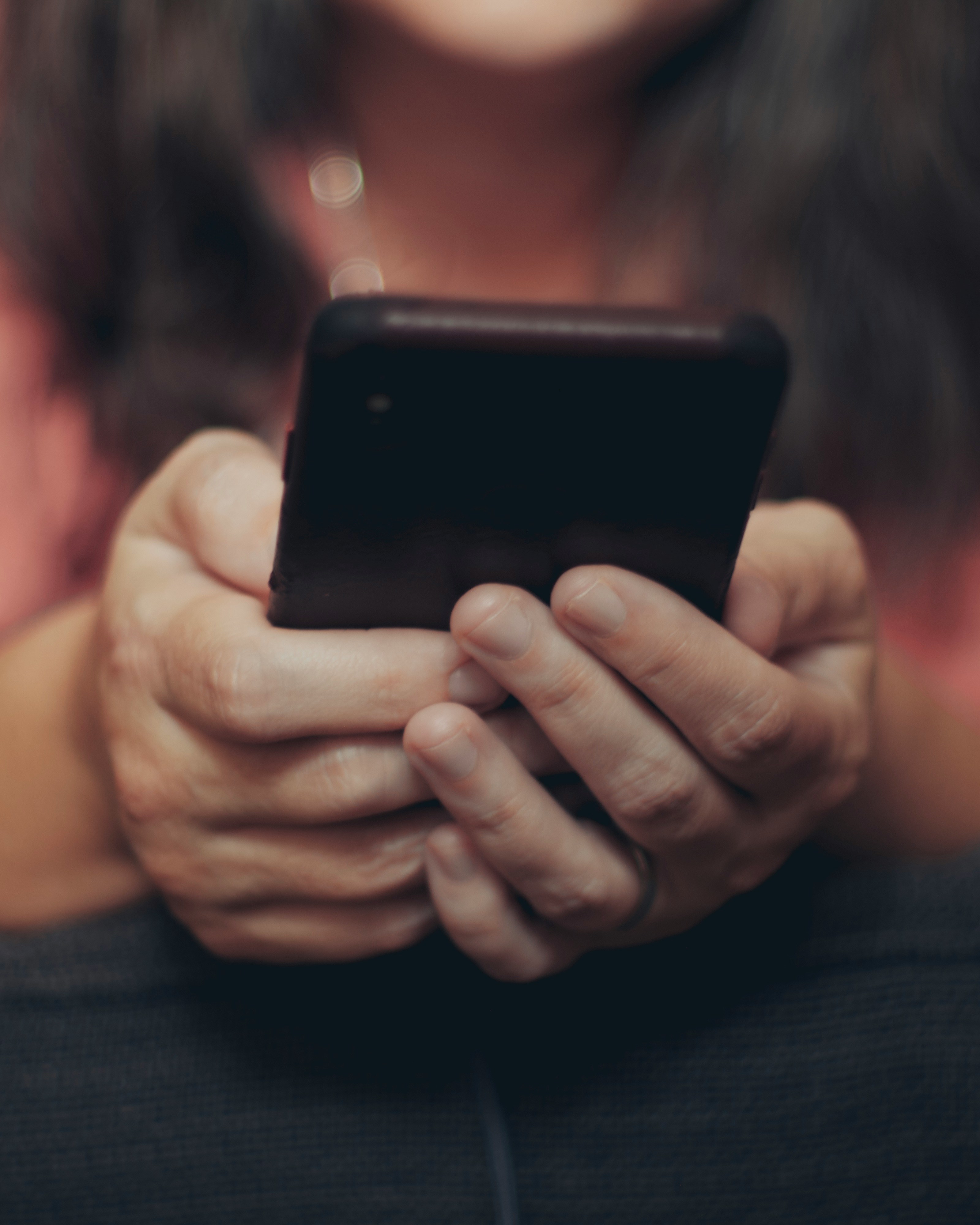 Une paire de mains tenant un téléphone portable | Source : Unsplash