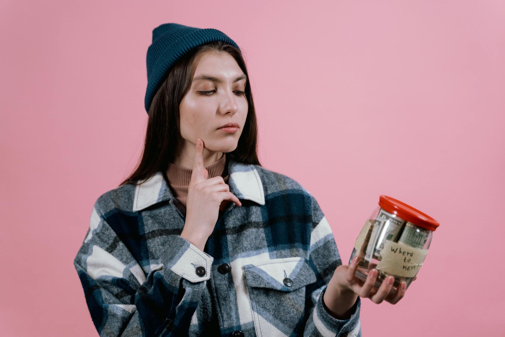 Une femme tenant un bocal en verre contenant de l'argent | Source : Pexels