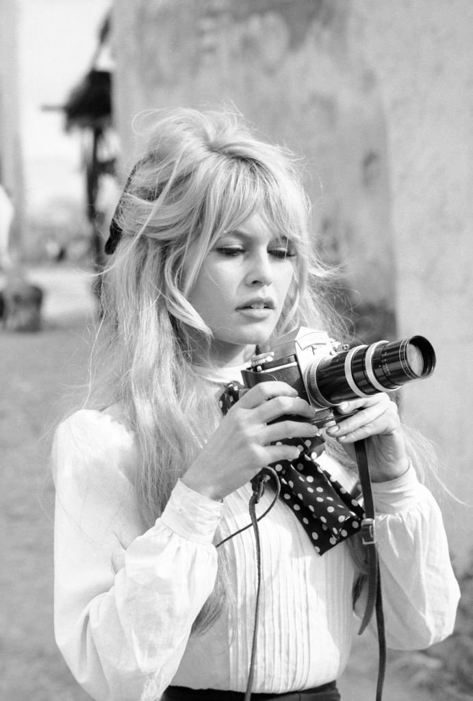 L'actrice française Brigitte Bardot tient un appareil photo pendant une pause dans le tournage du film 'Viva Maria' (réalisé par Louis Malle), Texcoco, Mexique, février 1965. | Photo : Getty Images