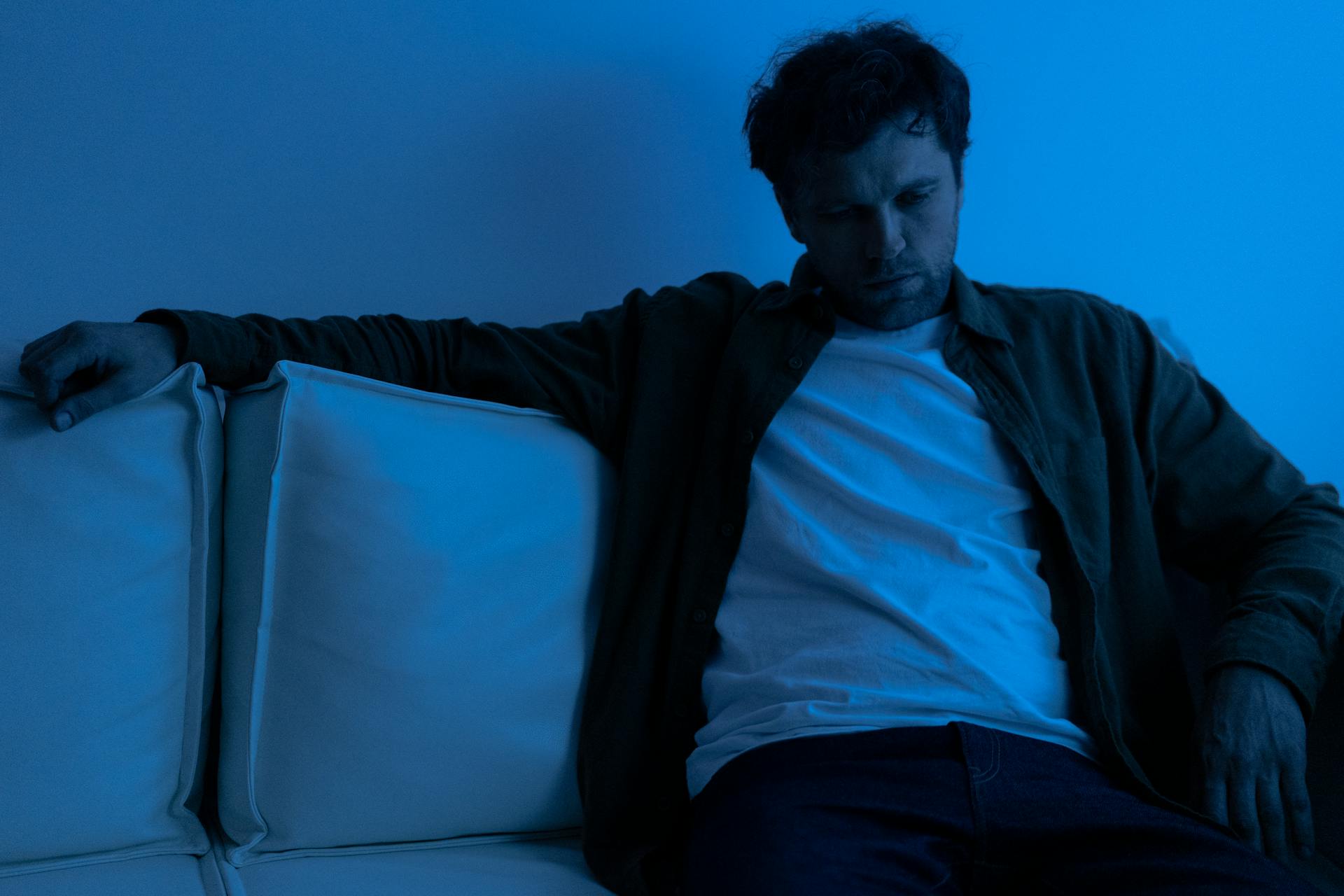 Un homme assis sur un canapé | Source : Pexels
